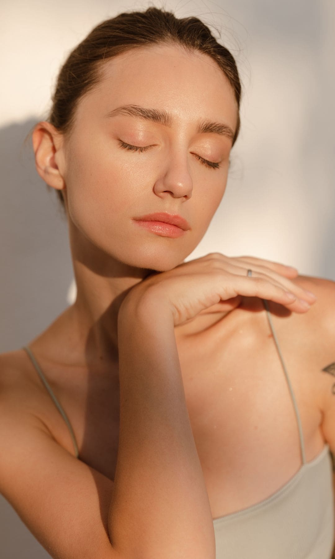 Mujer con la piel del rostro limpia y saludable, con los ojos cerrados en primer plano