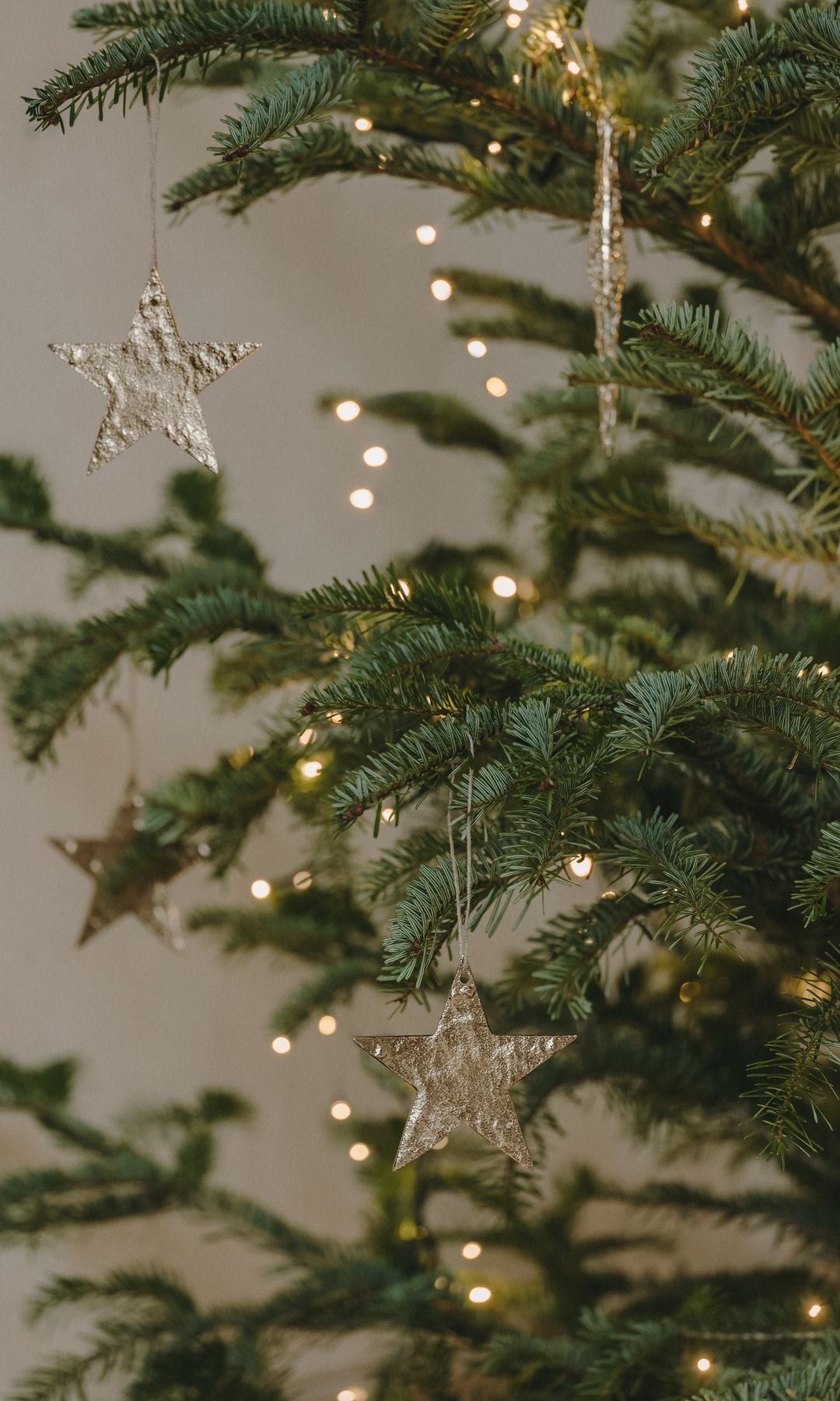 Adornos navideños de estrella en árbol de Navidad con guirnalda de luces 