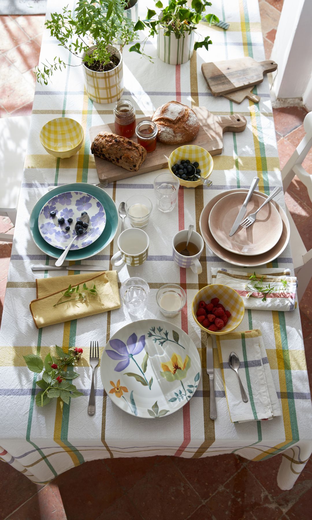 Mesa de verano con mantel a rayas y vajilla en tonos pastel
