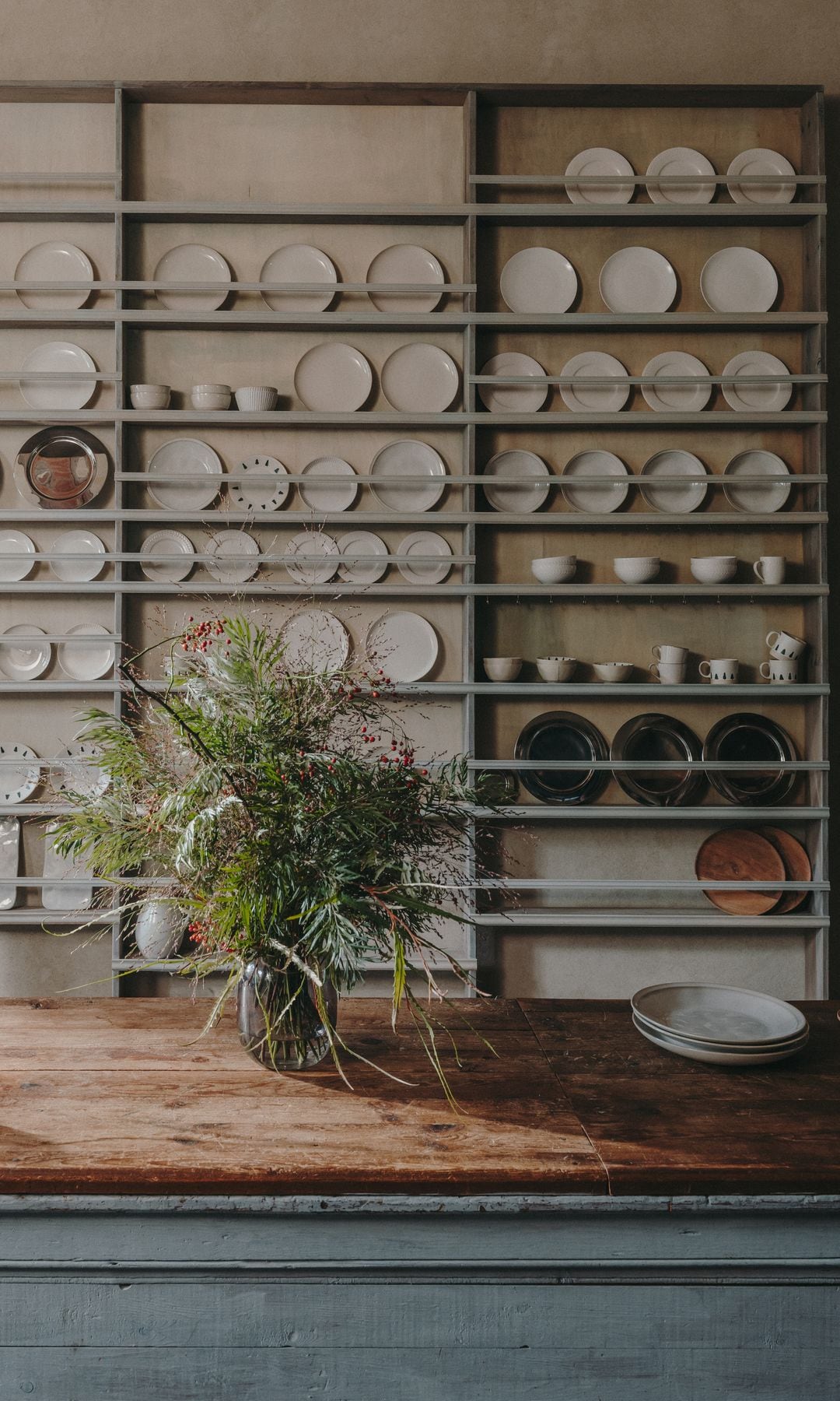 Vajillero de madera con platos y tazas y mesa tipo tocinera