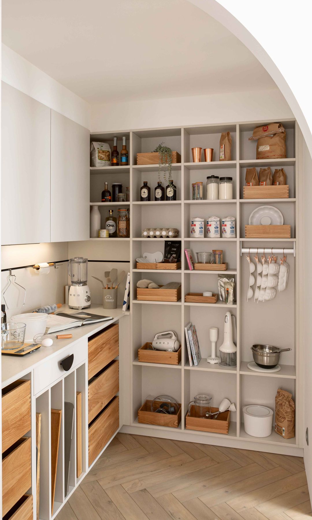 Cocina con una estantería que hace de despensa con botes de cristal y accesorios de madera