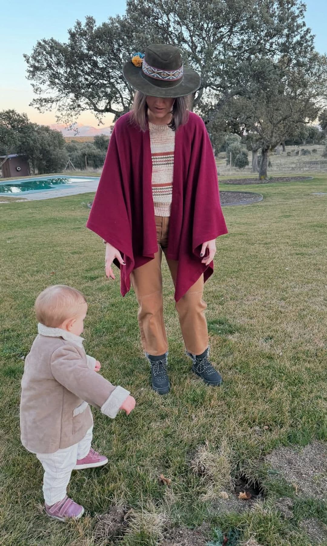 Isabelle Junot con capa y sombrero, junto a su hija en el campo