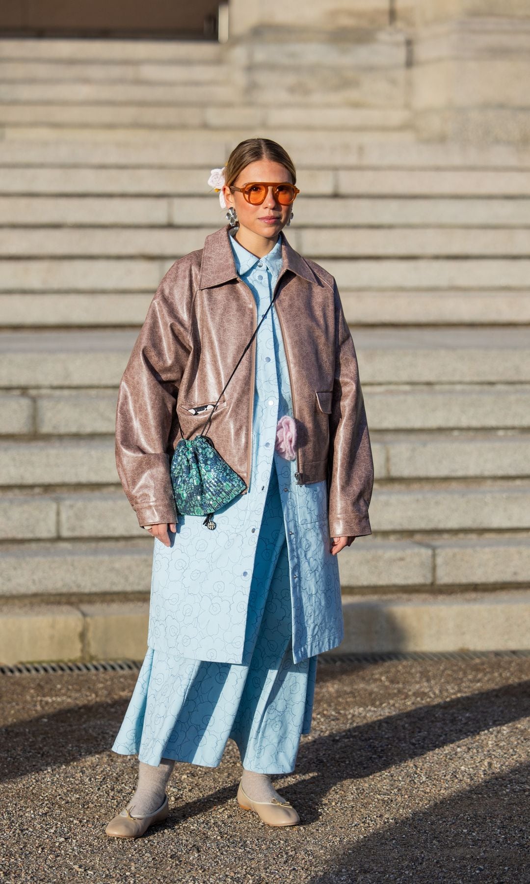 Rita Montezuma lleva bolso marrón, chaqueta de botones turquesa, falda, bolso, gafas de sol, banda de pelo floral fuera de Marimekko durante la Semana de la Moda de Copenhague AW24 el 01 de febrero 2024 en Copenhague, Dinamarca.