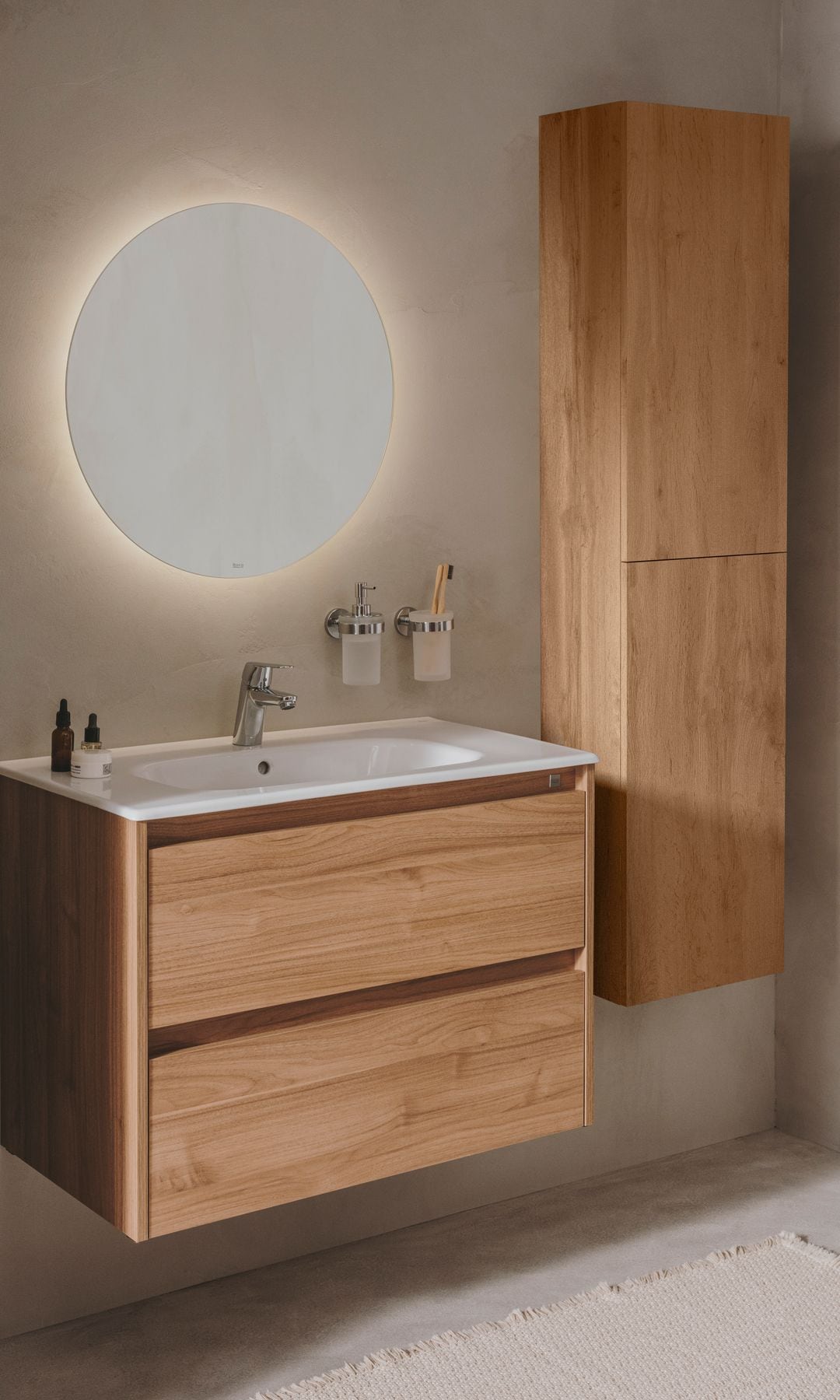 Baño con mueble bajolavabo y columna suspendidos de madera, lavabo encastrado, espejo retroiluminado redondo