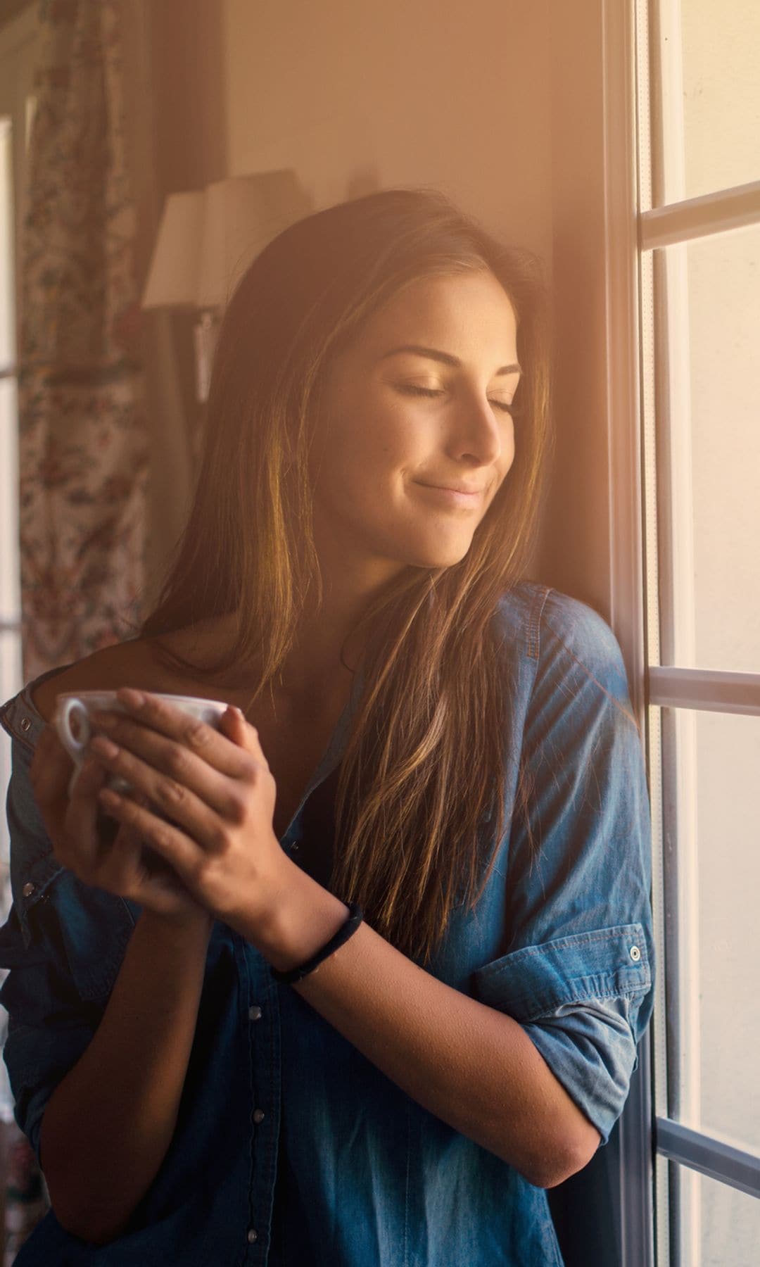 Mujer sonriendo por la mañana con un café después de tomar sus vitaminas