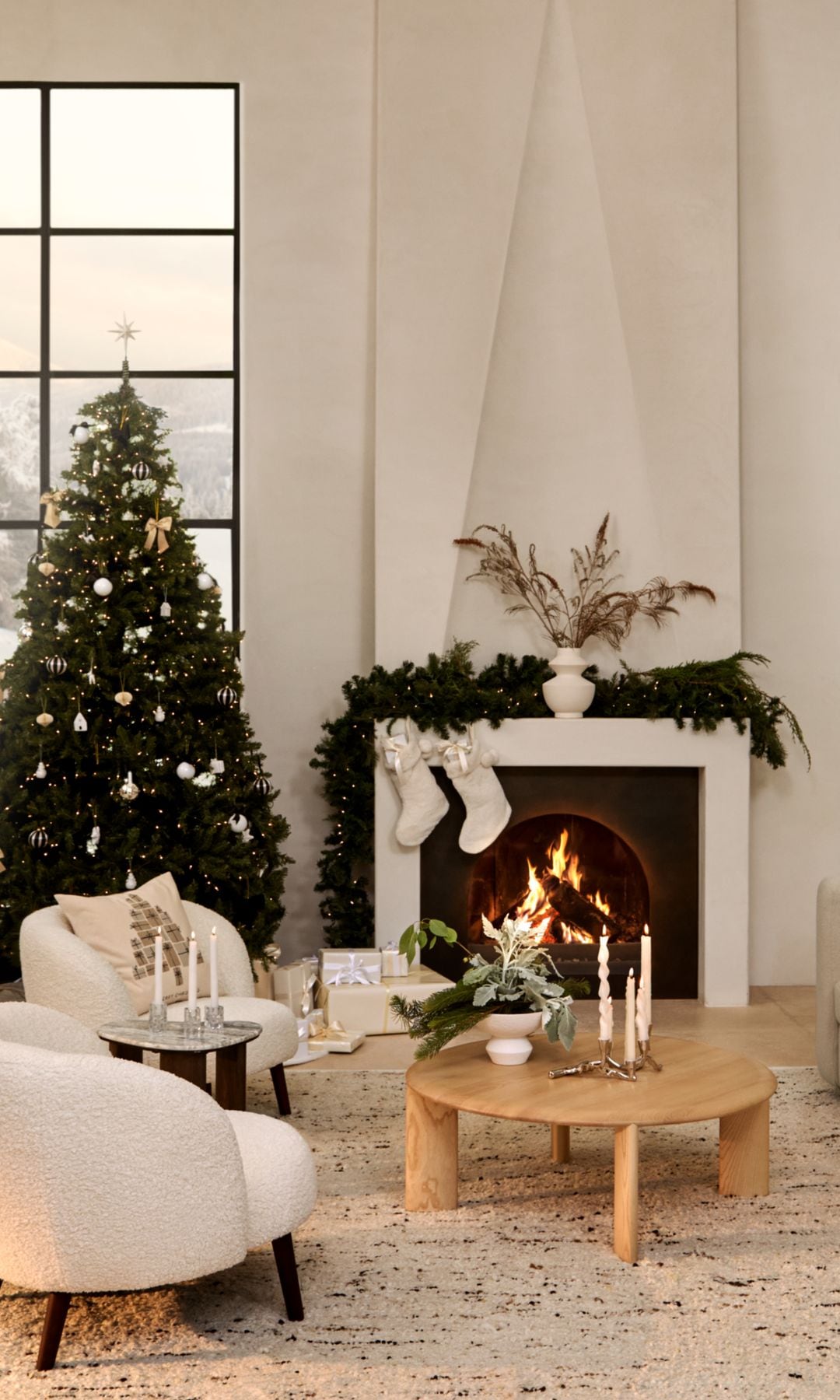 Salón blanco con chimenea con calcetines y árbol de Navidad 