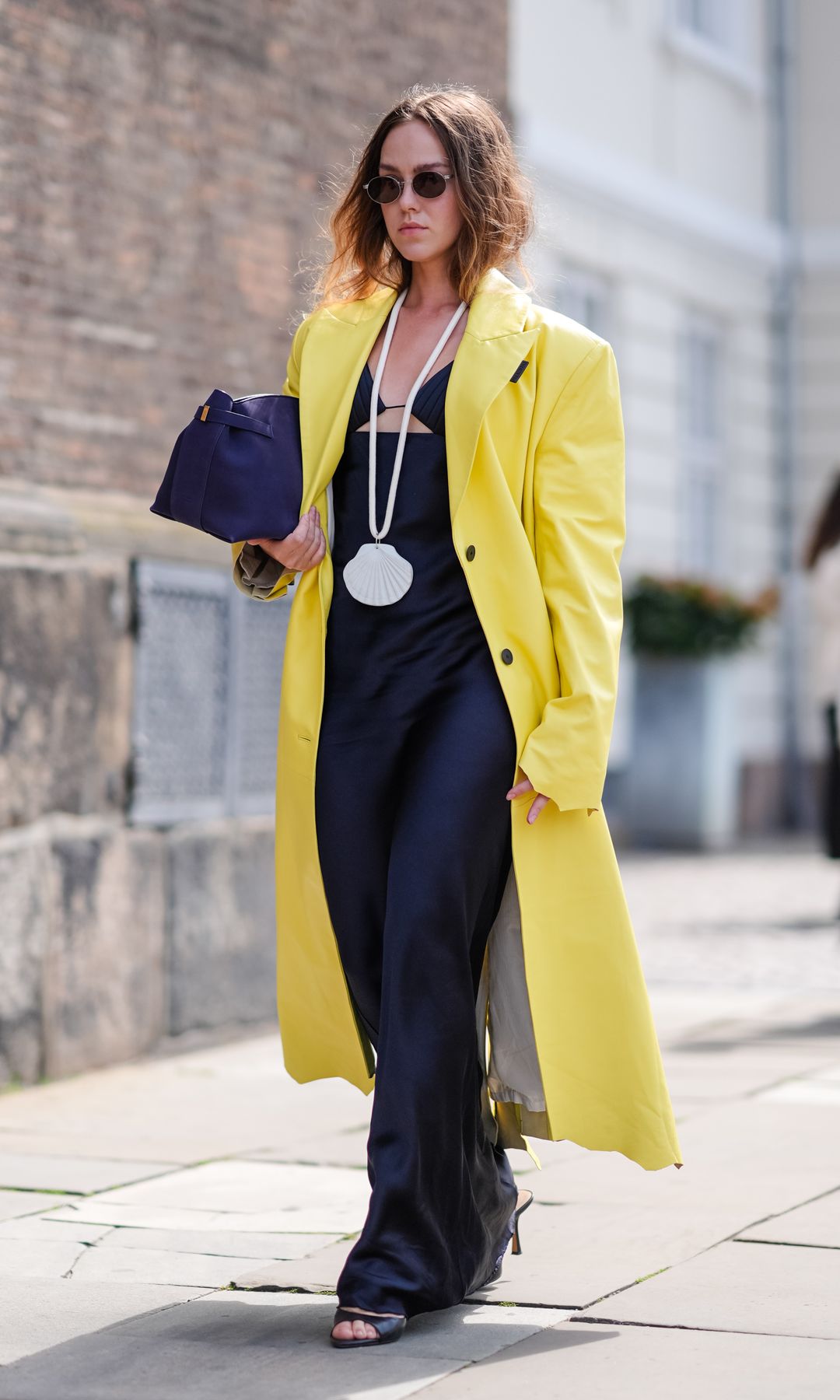 vestido azul marino con chubasquero amarillo y collar de concha