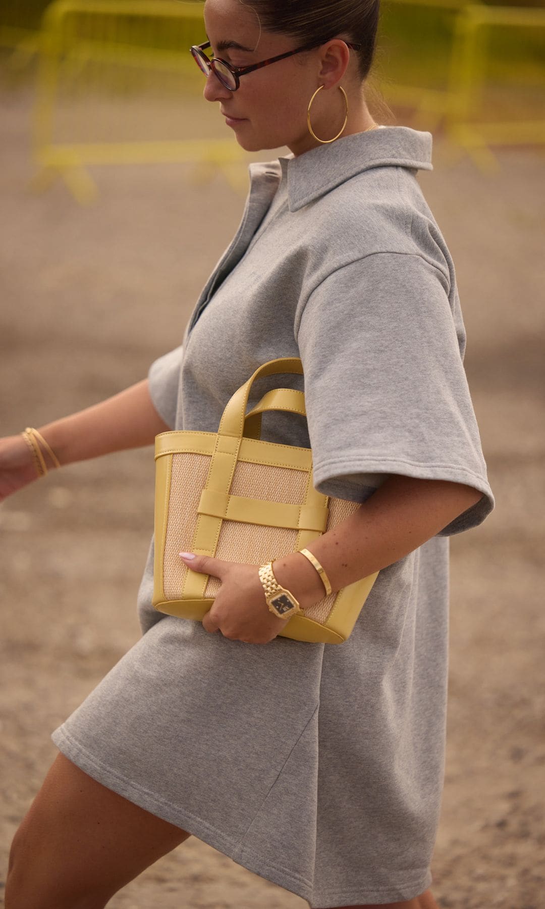 vestido corto con bolso amarillo y reloj de oro