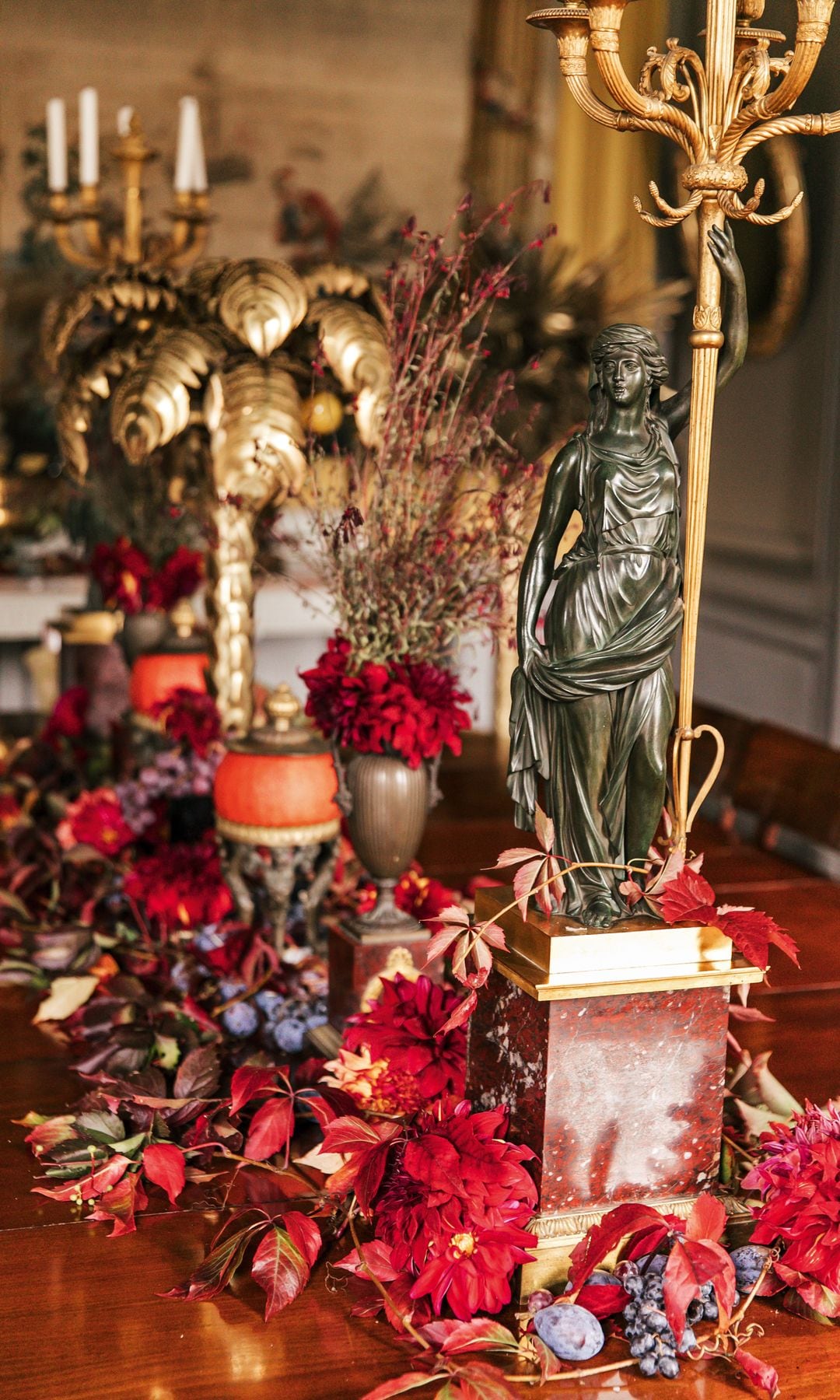 Detalle de la mesa decorada con arreglos florales de dalias rojas, flor que cultiva en uno de sus magníficos jardines: "Son ideales para los centros de mis mesas cuando recibo a mis amigos"