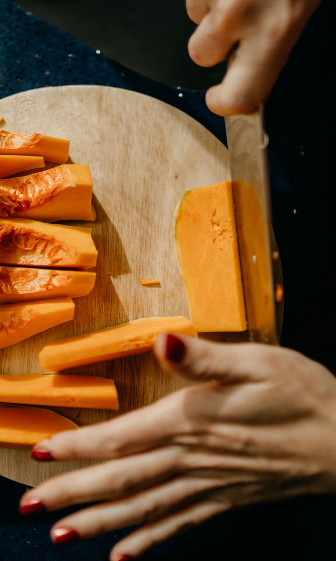 Mujer cocinando cortando con un cuchillo una calabaza