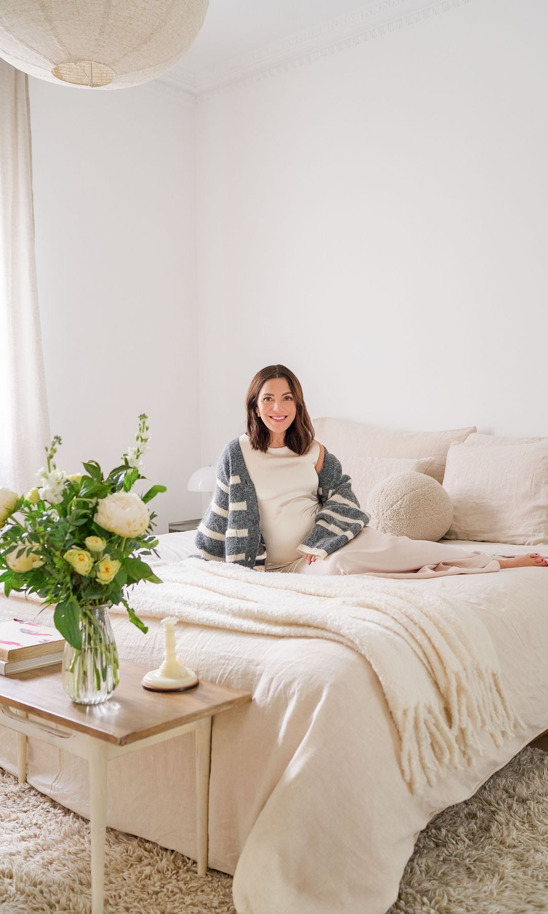 El dormitorio de Paula y su marido. La alfombra es de Lorena Canals; las cortinas, de Arteo Home; la lámpara de la mesilla, de Louis Poulsen y la del techo, de Zara Home. Las flores son de Muscari by Natalia Palacios.