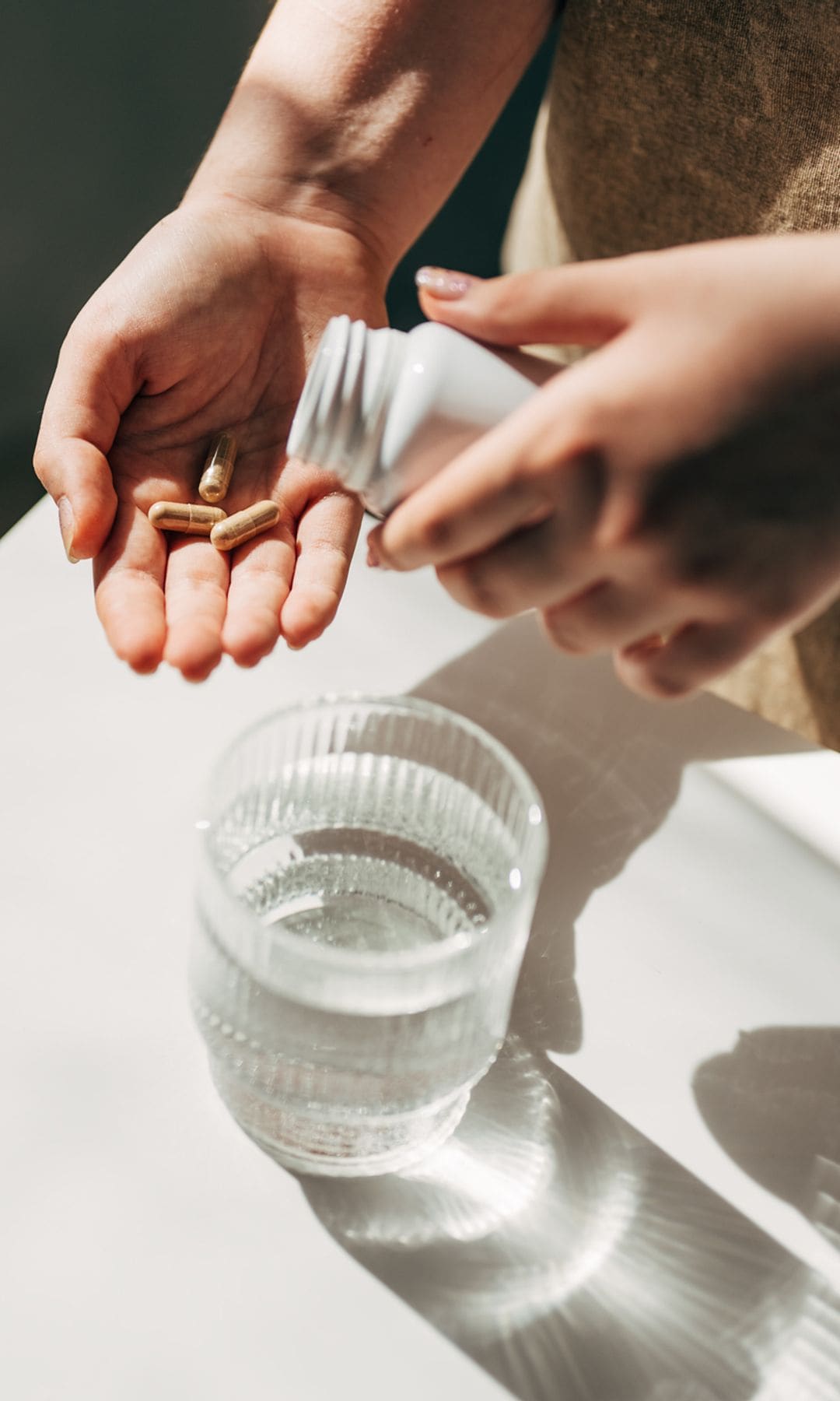 Mujer con un bote de pastillas suplementos alimenticios