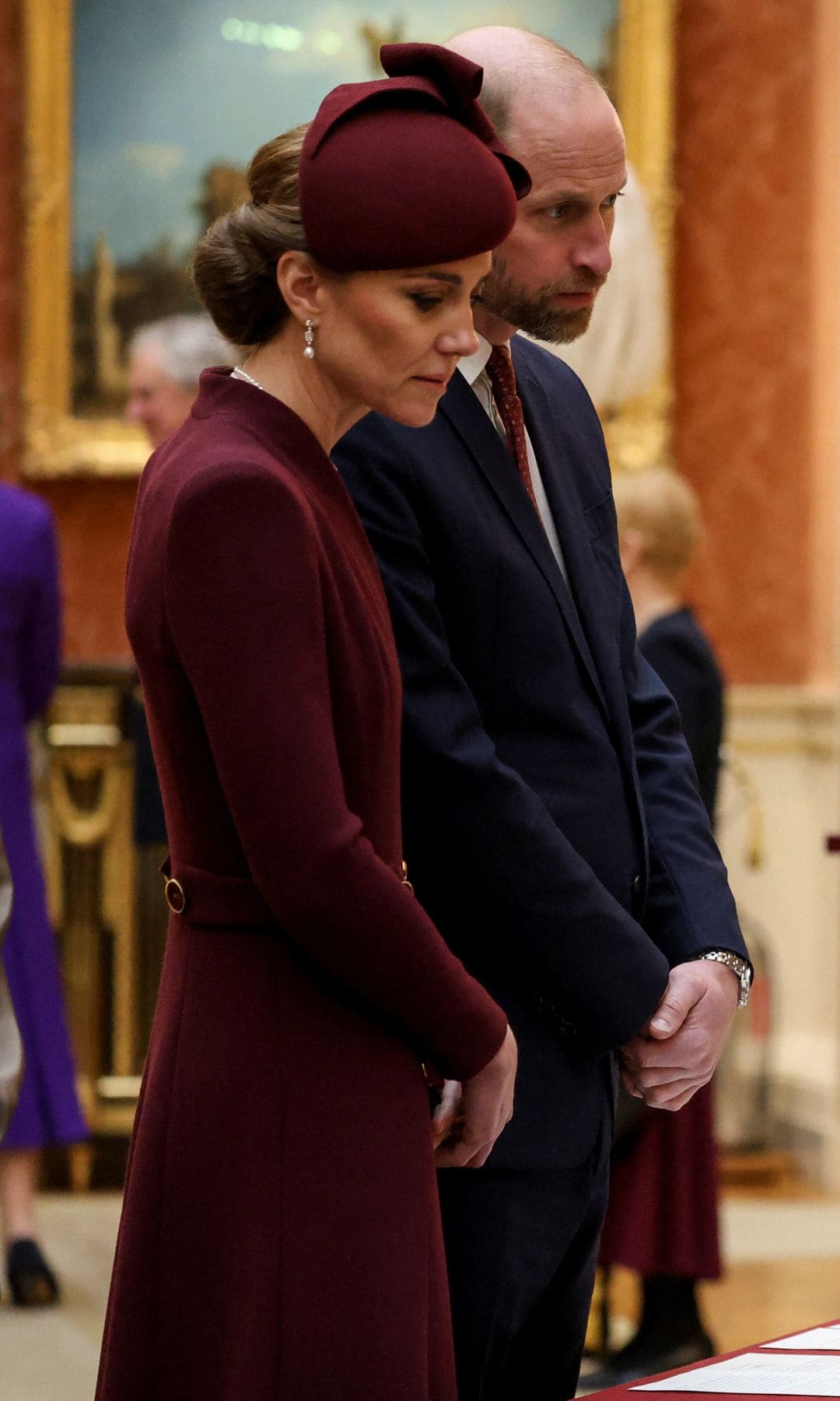 El segundo look de la princesa de Gales tenía como pieza protagonista un vestido tipo abrigo en color burdeos de Epinone London.