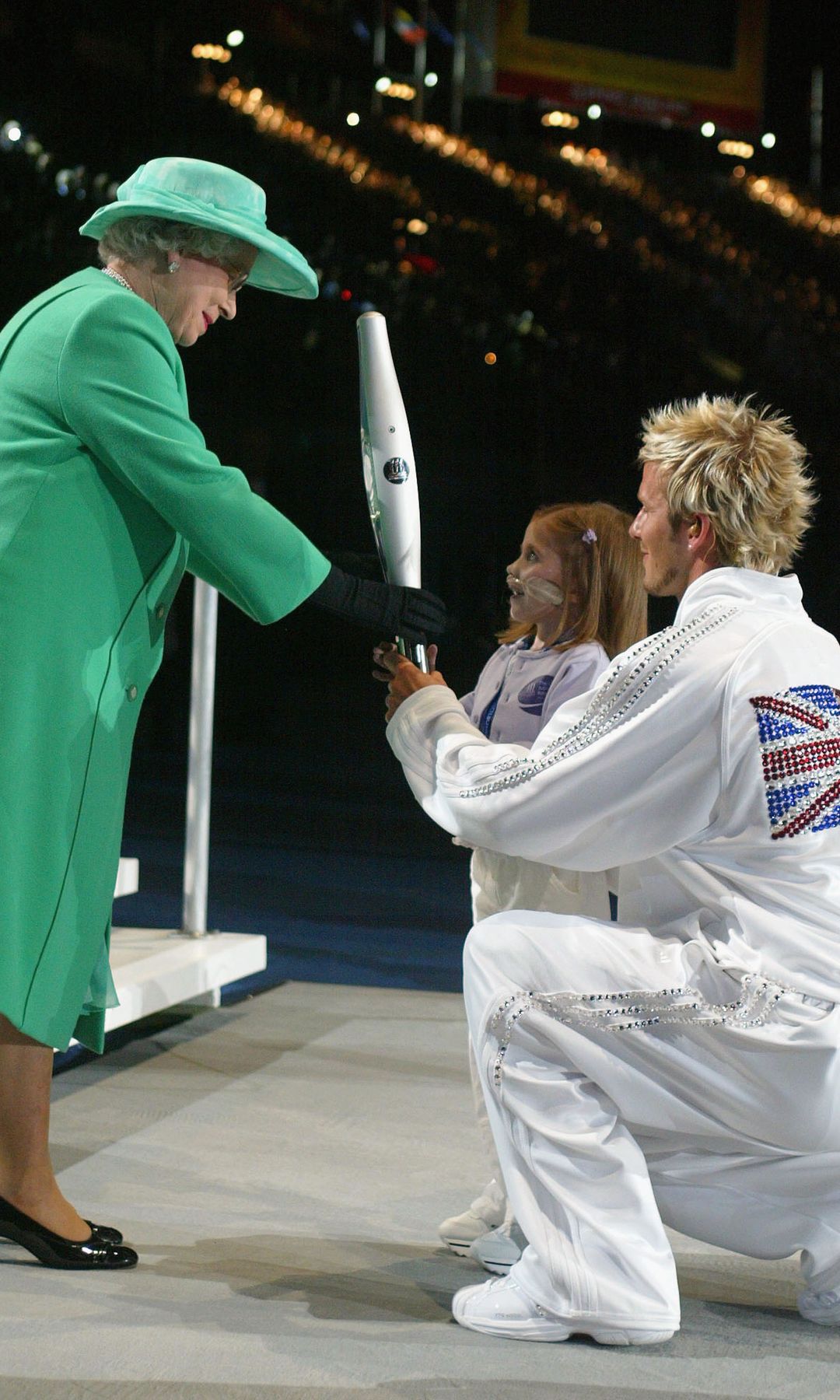 David Beckham, como capitán de la selección británica, junto a Isabel II en el estadio de Manchester en la inauguración de los Juegos de la Commonwealth del año 2005