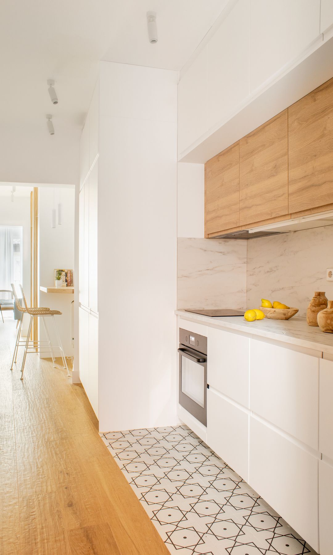 Cocina con muebles en color blanco y suelo geométrico