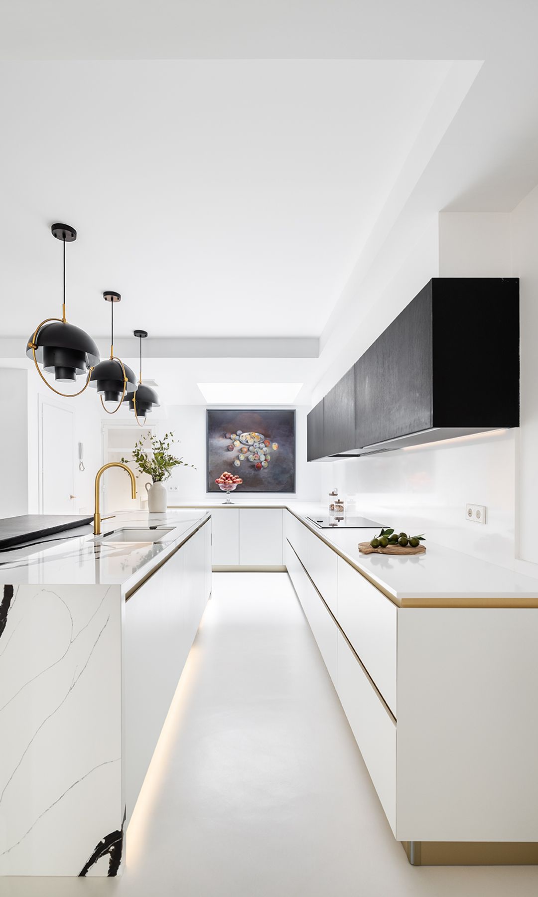 Cocina blanca con muebles superiores negros y detalles dorados 