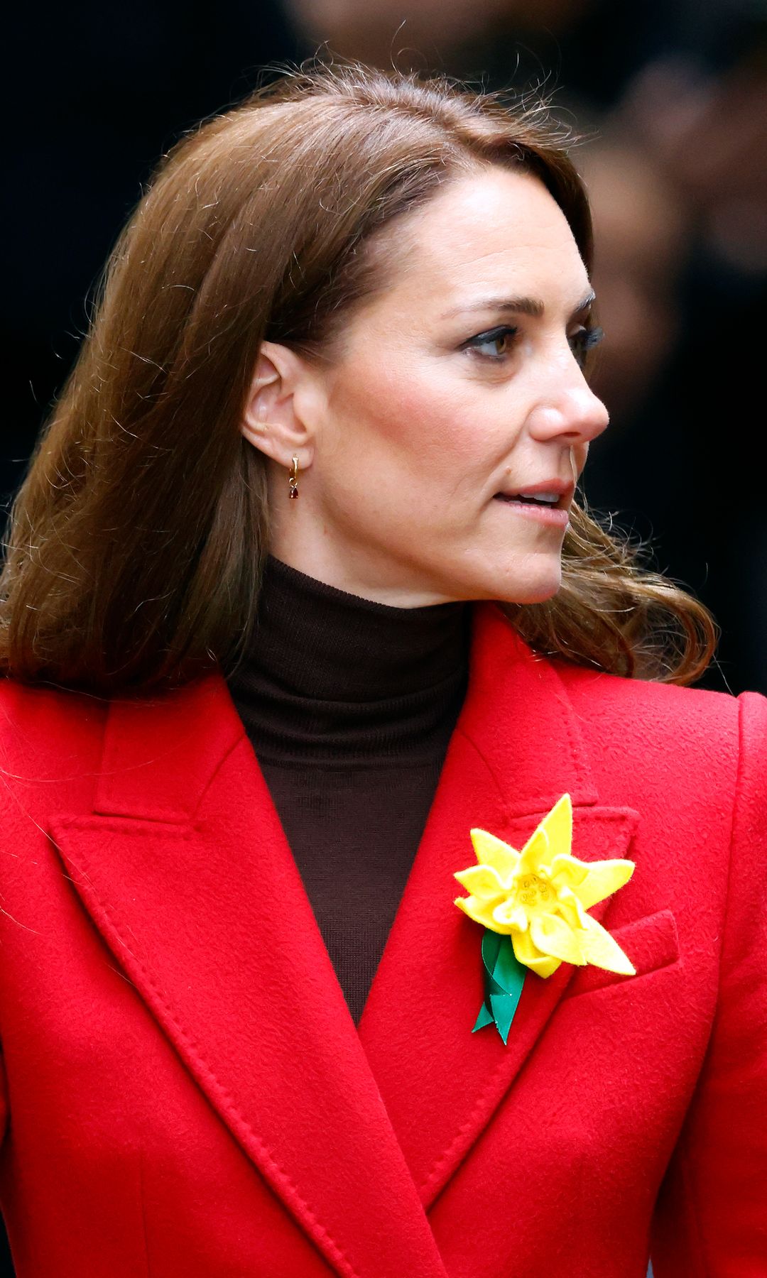 Kate Middleton con abrigo rojo y flor amarilla en la solapa