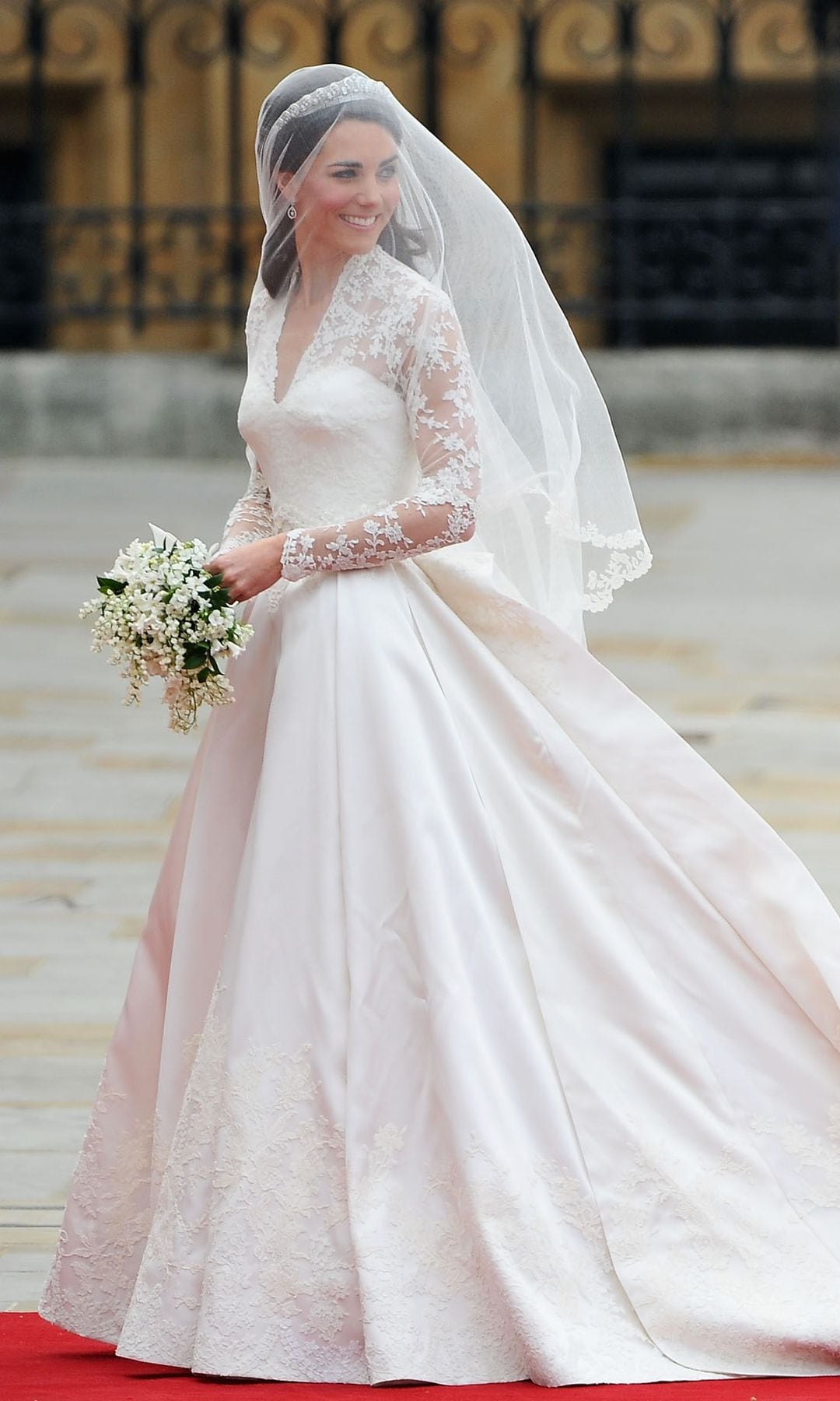 Kate Middleton saluda a la multitud mientras su hermana y dama de honor, Pippa Middleton, sostiene su vestido antes de entrar en la Abadía para asistir a la boda real del Príncipe William con Catherine Middleton en la Abadía de Westminster el 29 de abril de 2011 en Londres, Inglaterra. 