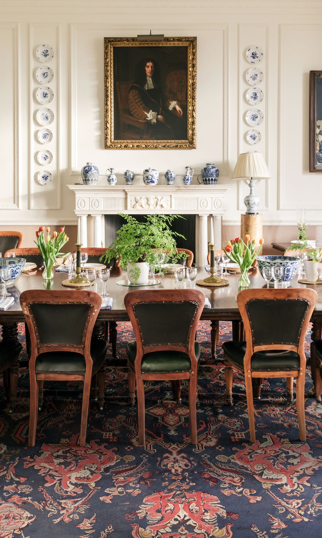 Detalles del comedor de la mansión, presidido por una chimenea y cuadros de la colección familiar. La porcelana azul y blanca que adorna las paredes es de Meissen y la porcelana de la mesa está adornada con bordes dorados y el escudo de la familia. 