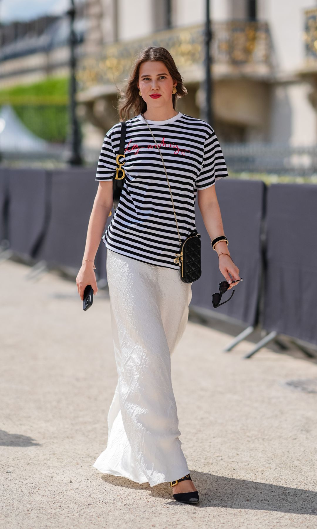 Camiseta oversize rayas marineras, falda larga blanca con estampado fluido y zapatos planos con punta en punta
