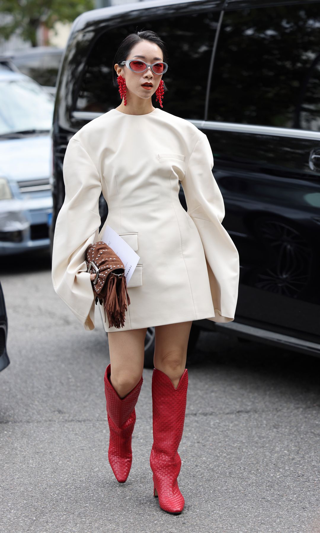 Vestido blanco, botas rojas y bolso de flecos