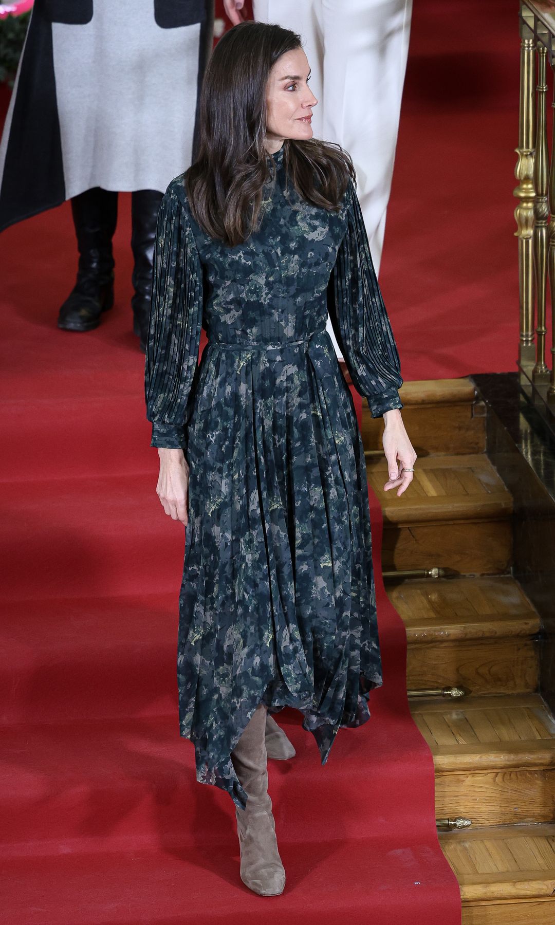 Reina Letizia con vestido estampado plisado y botas de ante marrones 