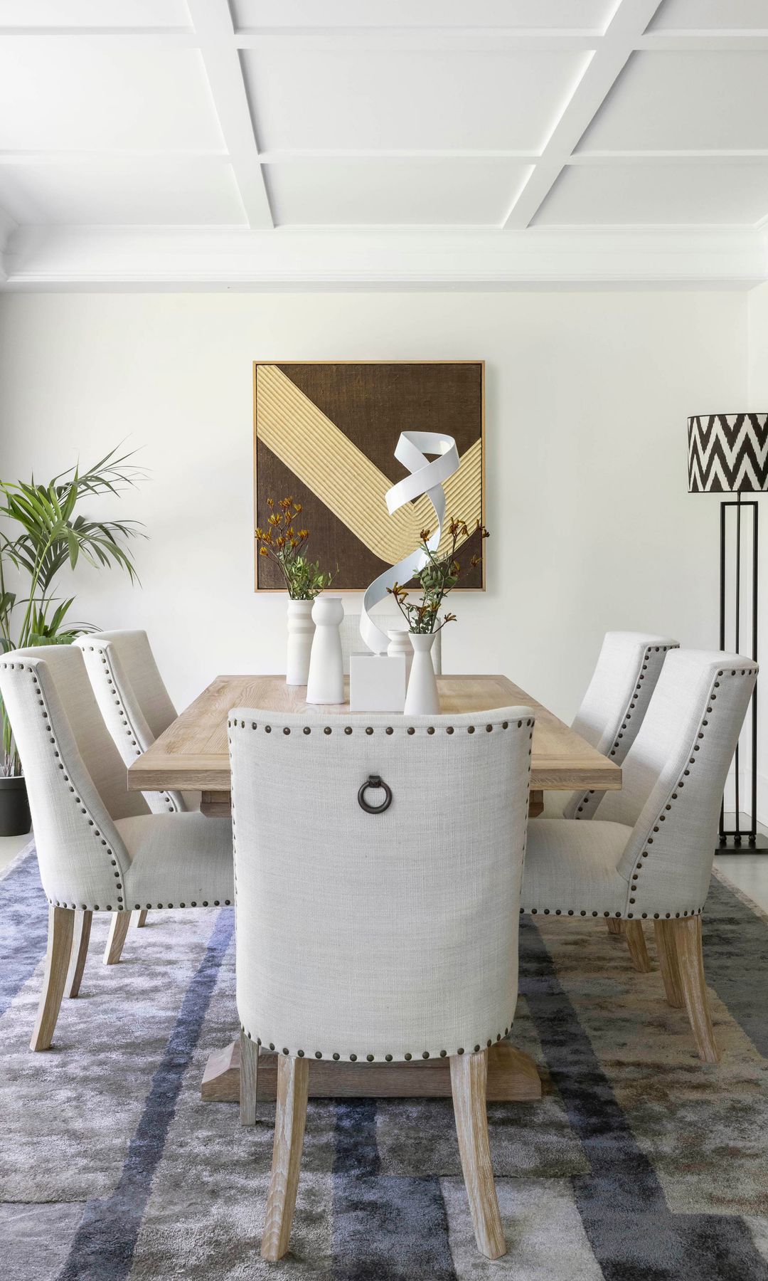 Comedor de estilo contemporáneo con arte y arreglos sobre la mesa