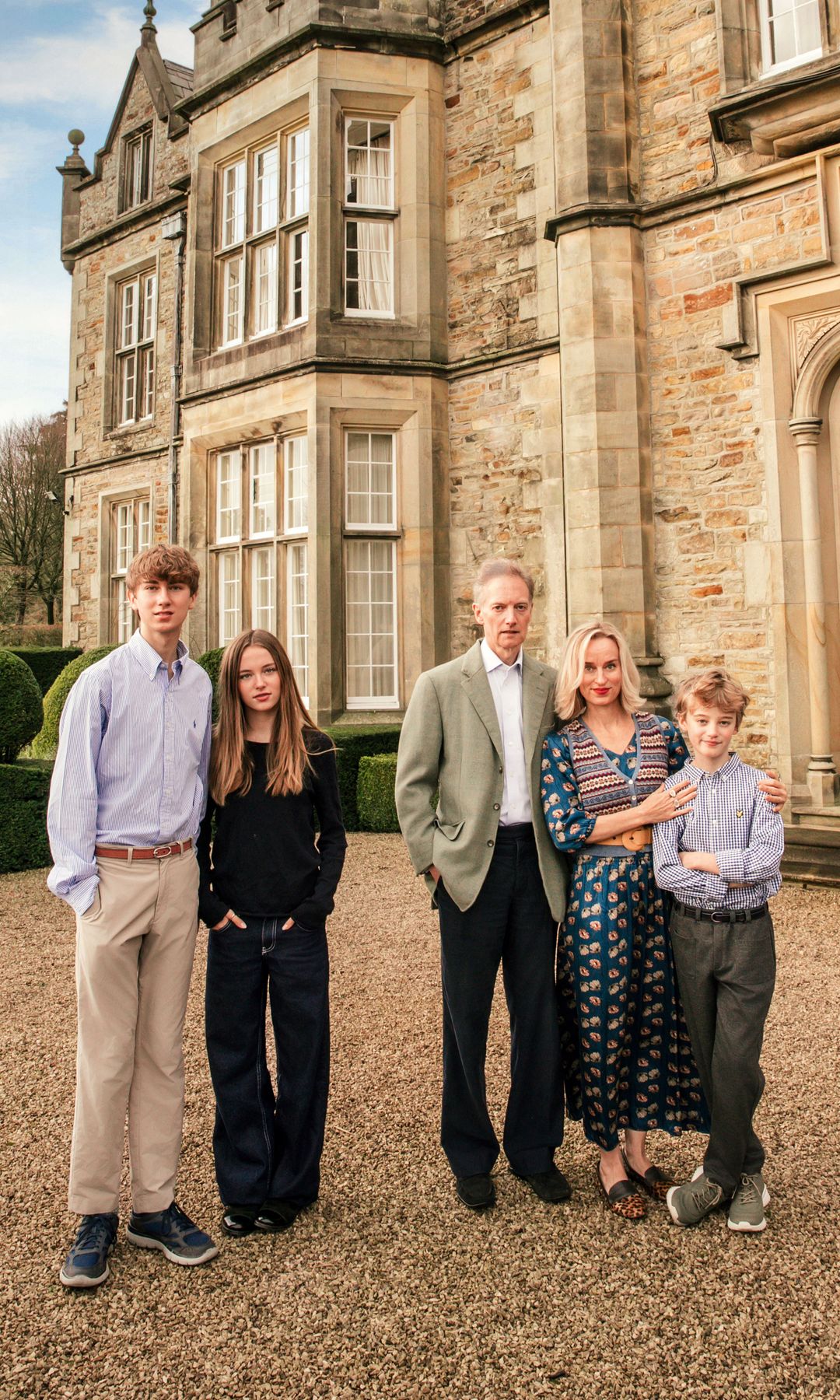 El matrimonio posa junto a sus tres hijos, Alexander, Iona y Harry, delante de la fachada principal