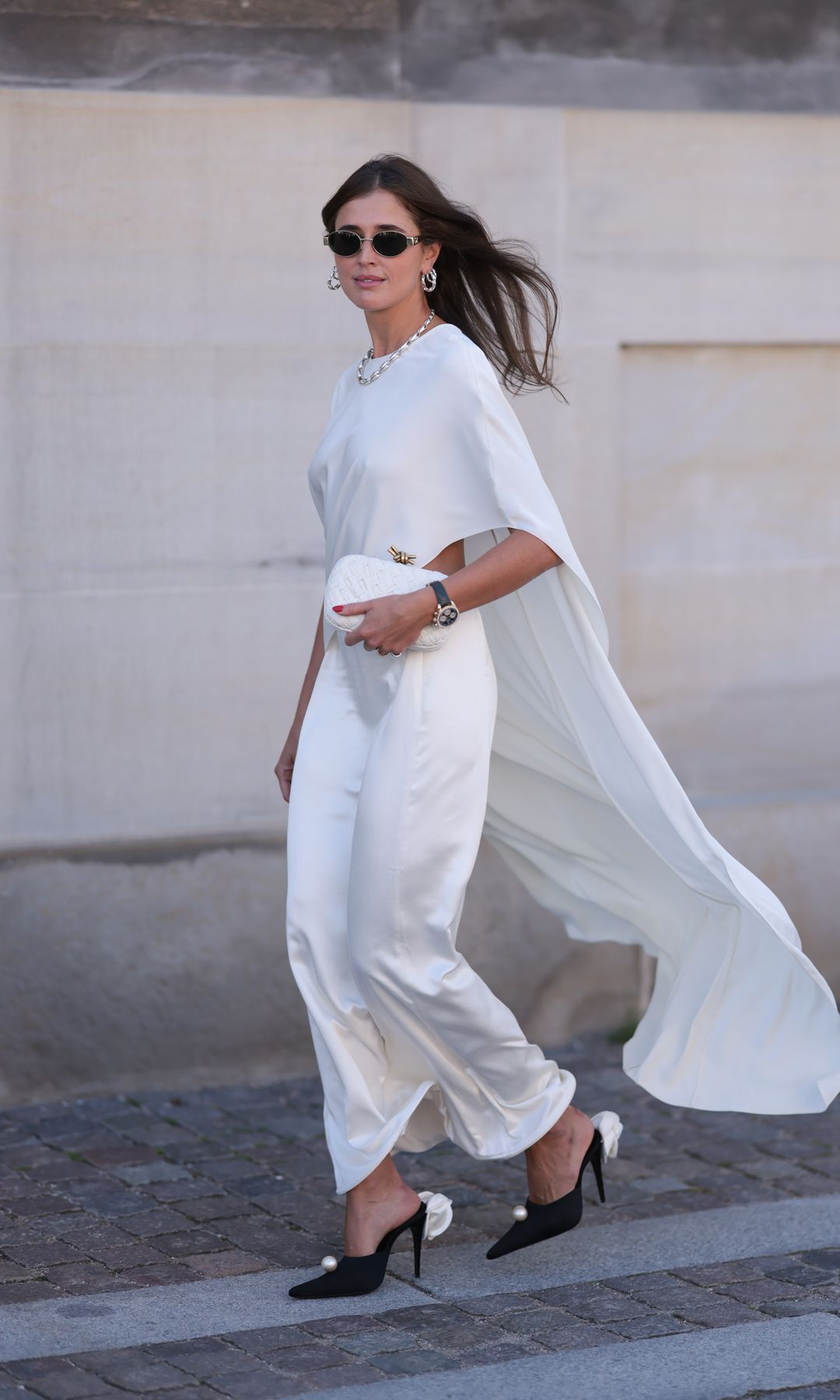 Darja Barannik fue vista llevando un vestido largo de satén blanco. También llevaba zapatos negros de tacón con una flor blanca y una perla blanca, pendientes de perlas, un collar de perlas y gafas de sol negras de Celine, antes del desfile de Lovechild 1979 durante el segundo día de la Semana de la Moda de Copenhague (CPHFW) Primavera/Verano 2025 el 6 de agosto de 2024 en Copenhague, Dinamarca.