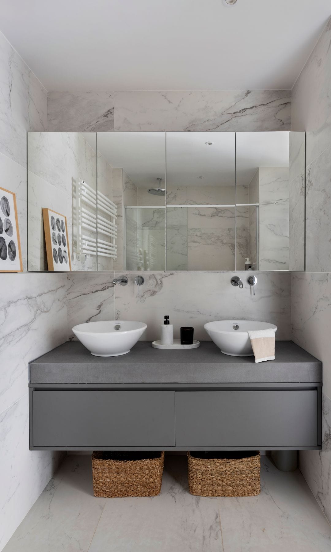 Baño con armario con puertas de espejo, mueble gris y cestos