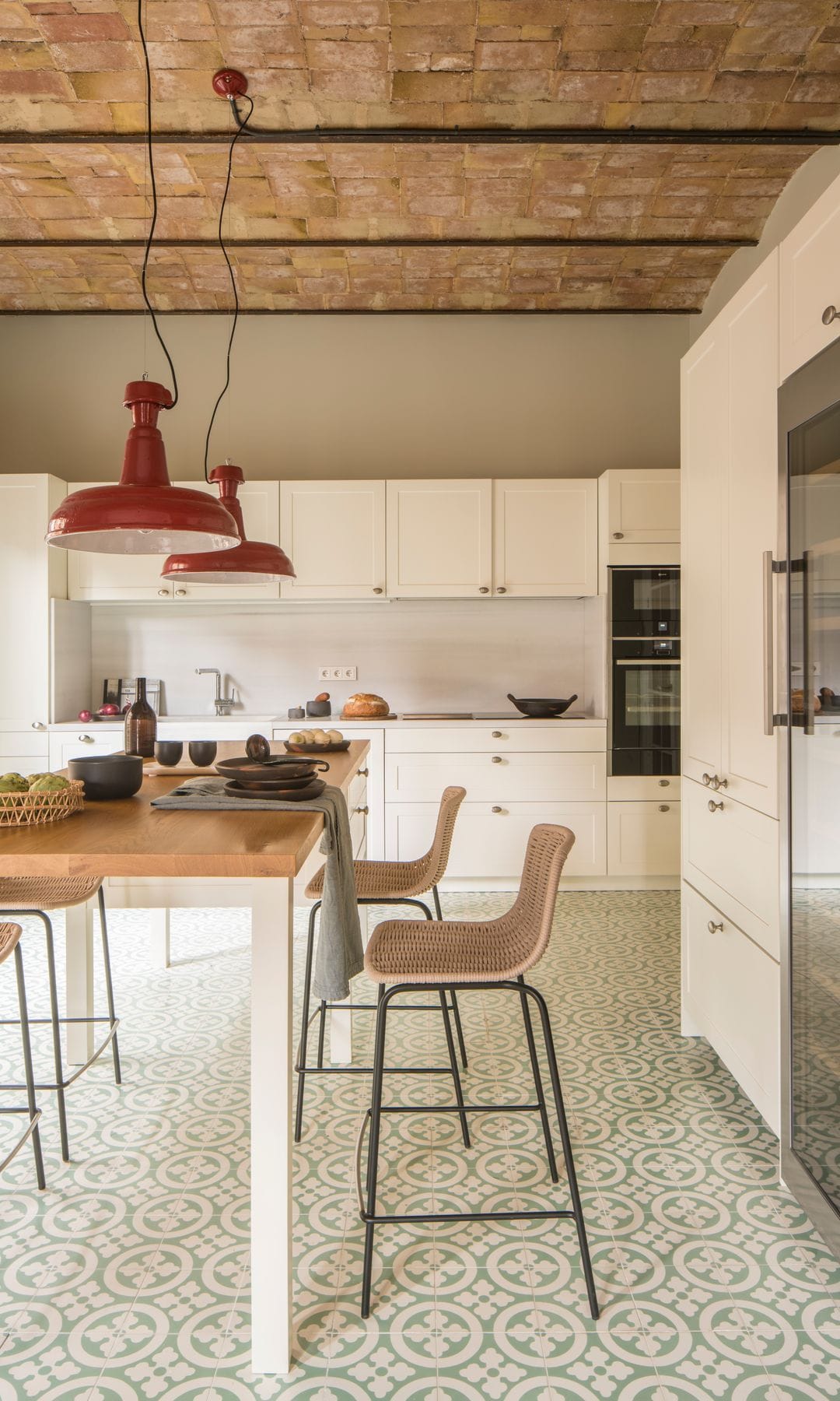 Cocina con muebles en color blanco y suelo hidráulico