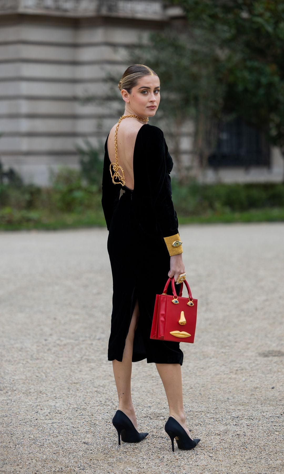 Valentina Ferragni lleva vestido negro de terciopelo sin espalda con abertura, bolso rojo, tacones, collar fuera de Schiaparelli durante la Semana de la Moda de París - Alta Costura Primavera Verano : Día Uno el 23 de enero de 2023 en París, Francia.