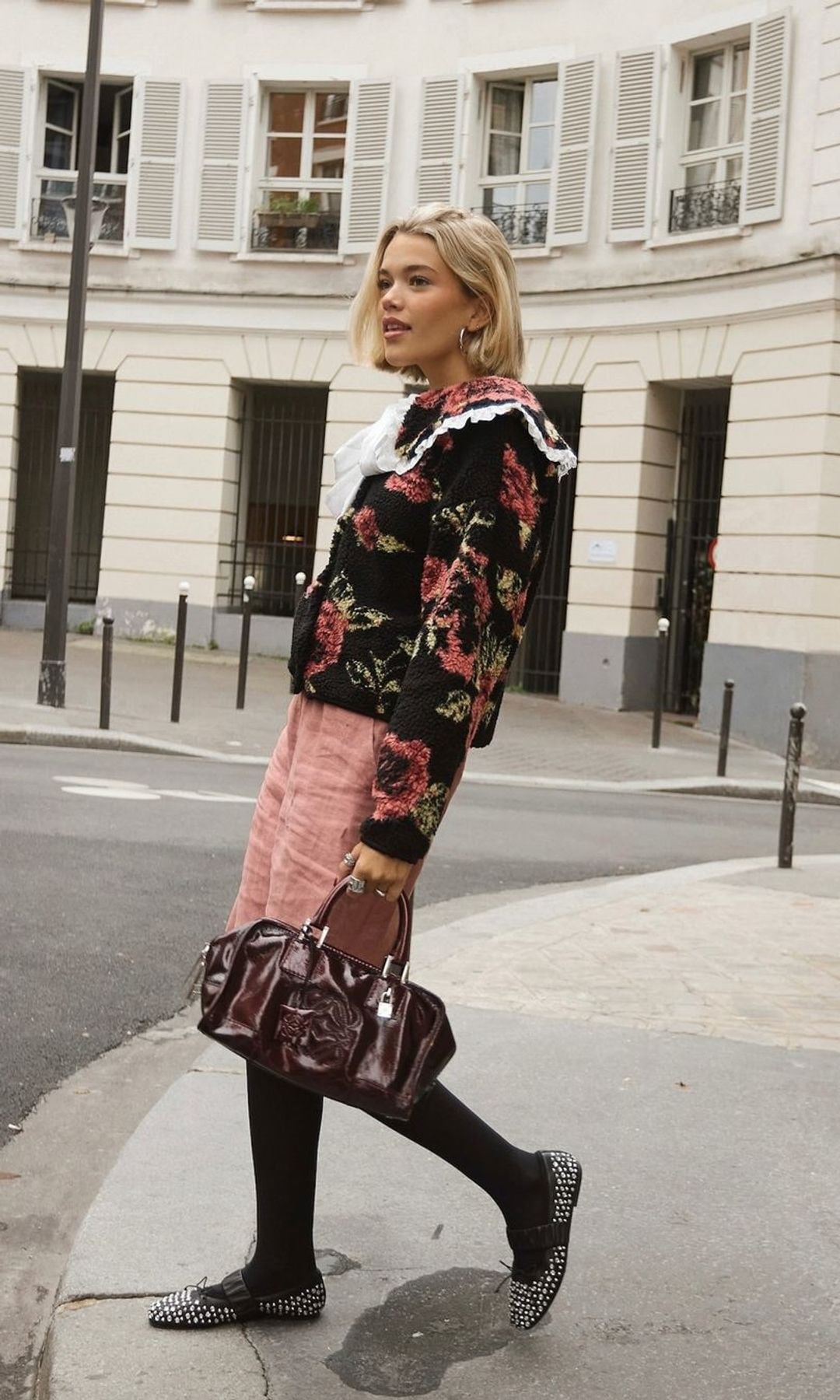 camisa de flores con volantes, bermudas rosas, bailarinas con tachuelas y bolso granate