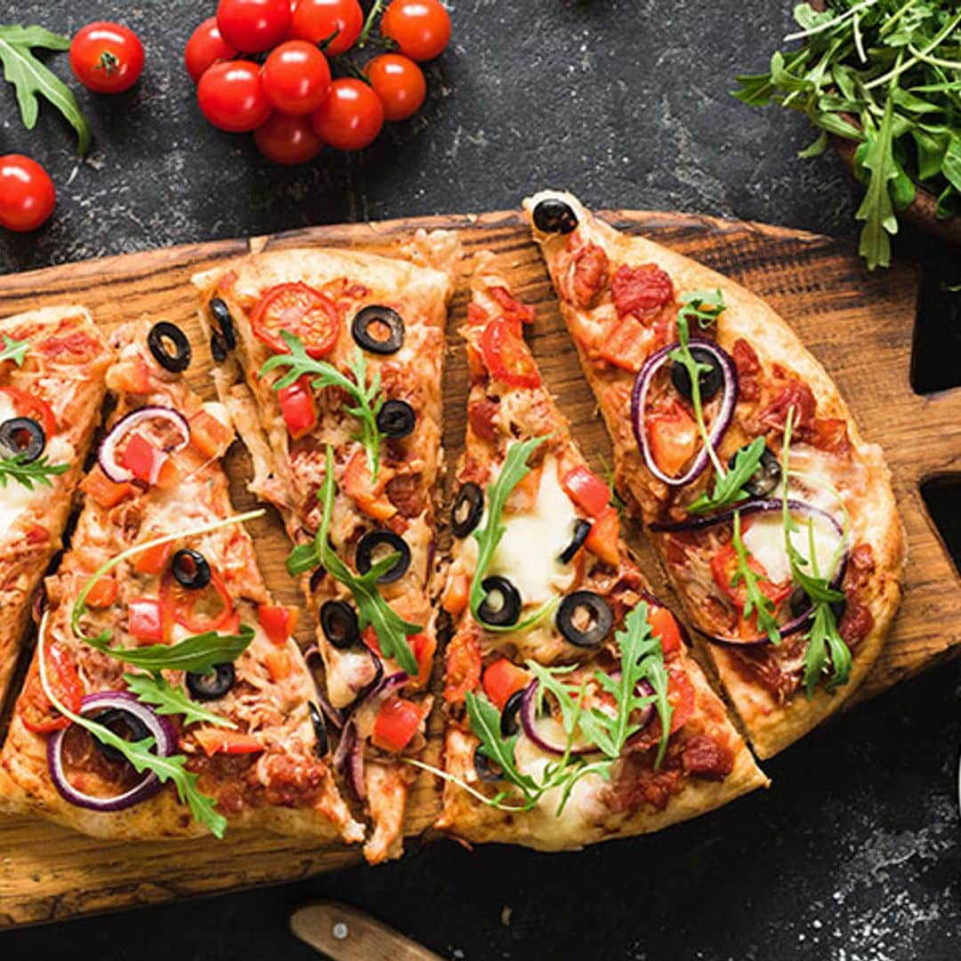 Pizza casera con tomate fresco, aceitunas y rúcula