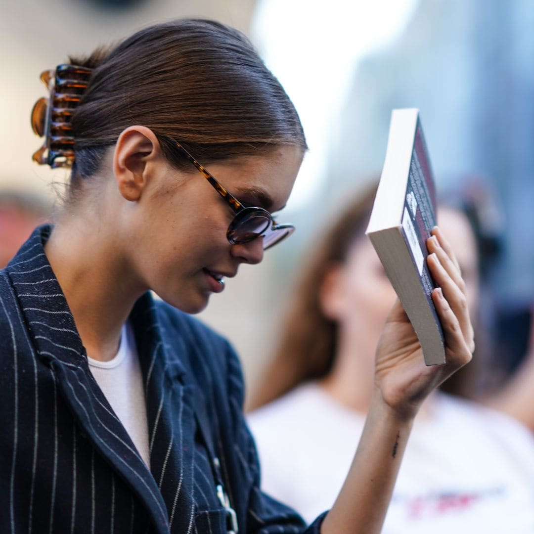 Kaia Gerber en Paris Fashion Week con un libro en la mano