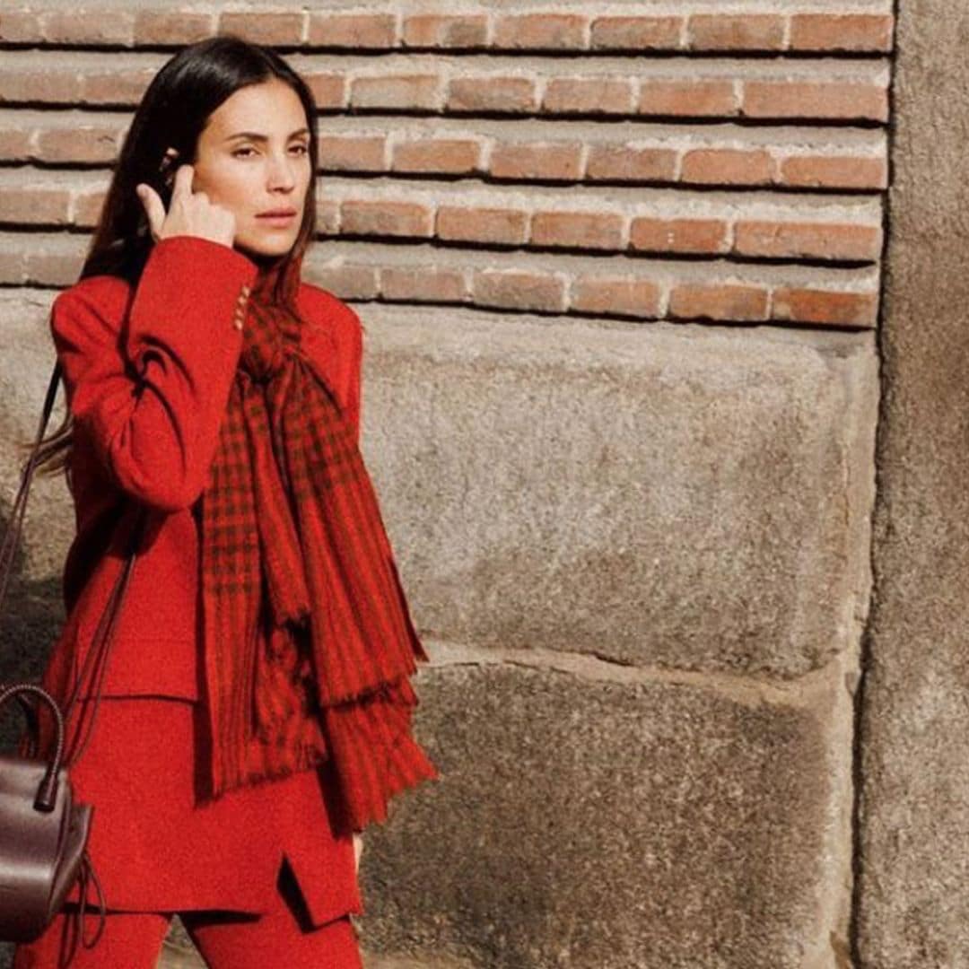 El look navideño de Sassa de Osma con traje rojo, bufanda estampada y bolso de Ubrique