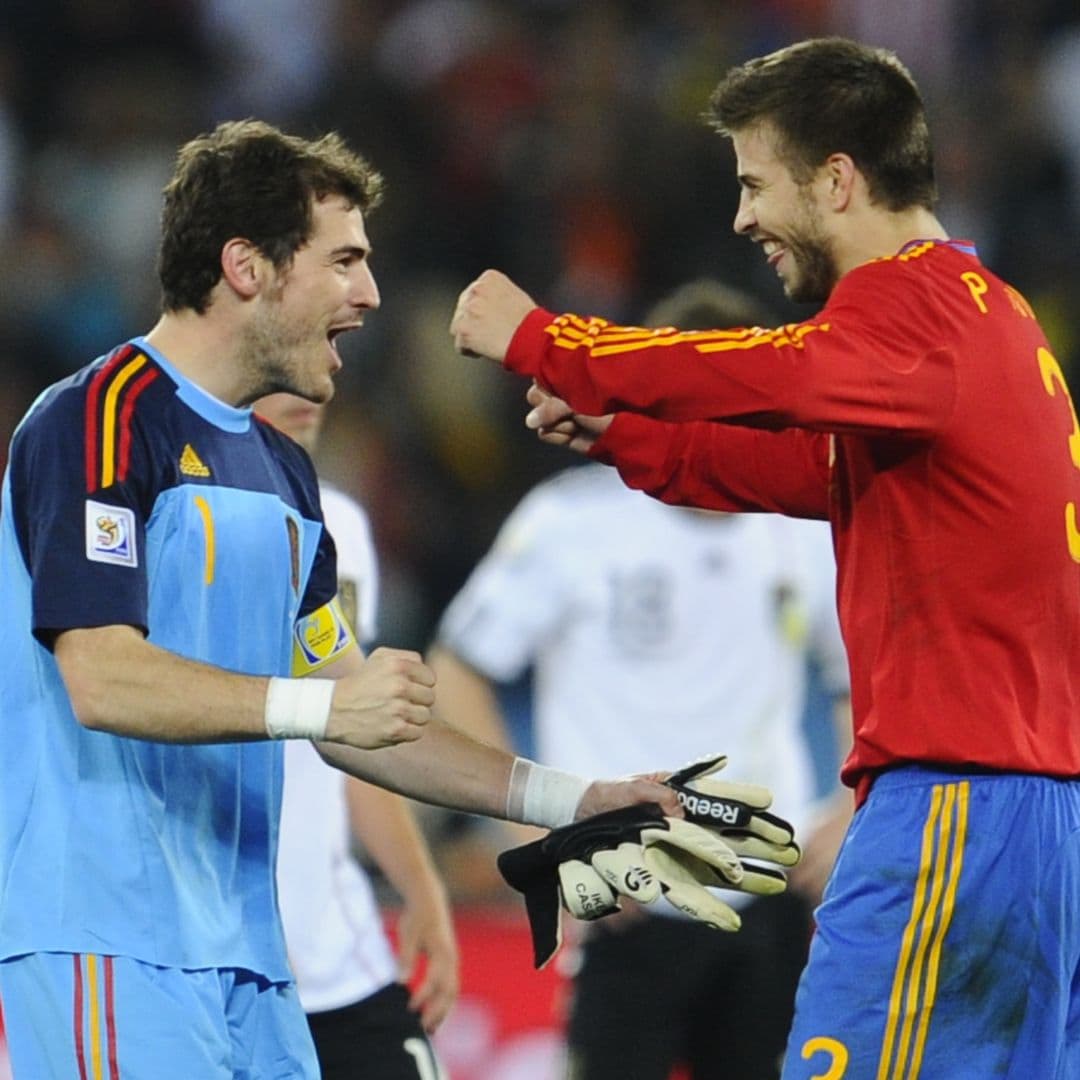 Spain's goalkeeper Iker Casillas (L) celebrates with Spain's defender Gerard Pique (C) as Germany's defender Arne Friedrich (R) looks dejected at the end of the 2010 World Cup semi-final football match between Germany and Spain on July 7, 2010 at Moses Mabhida stadium in Durban. Spain won the match 1-0 to advance to the final on July 11 against the Netherlands.    NO PUSH TO MOBILE / MOBILE USE SOLELY WITHIN EDITORIAL ARTICLE        AFP PHOTO / PIERRE-PHILIPPE MARCOU (Photo credit should read PIERRE-PHILIPPE MARCOU/AFP via Getty Images)