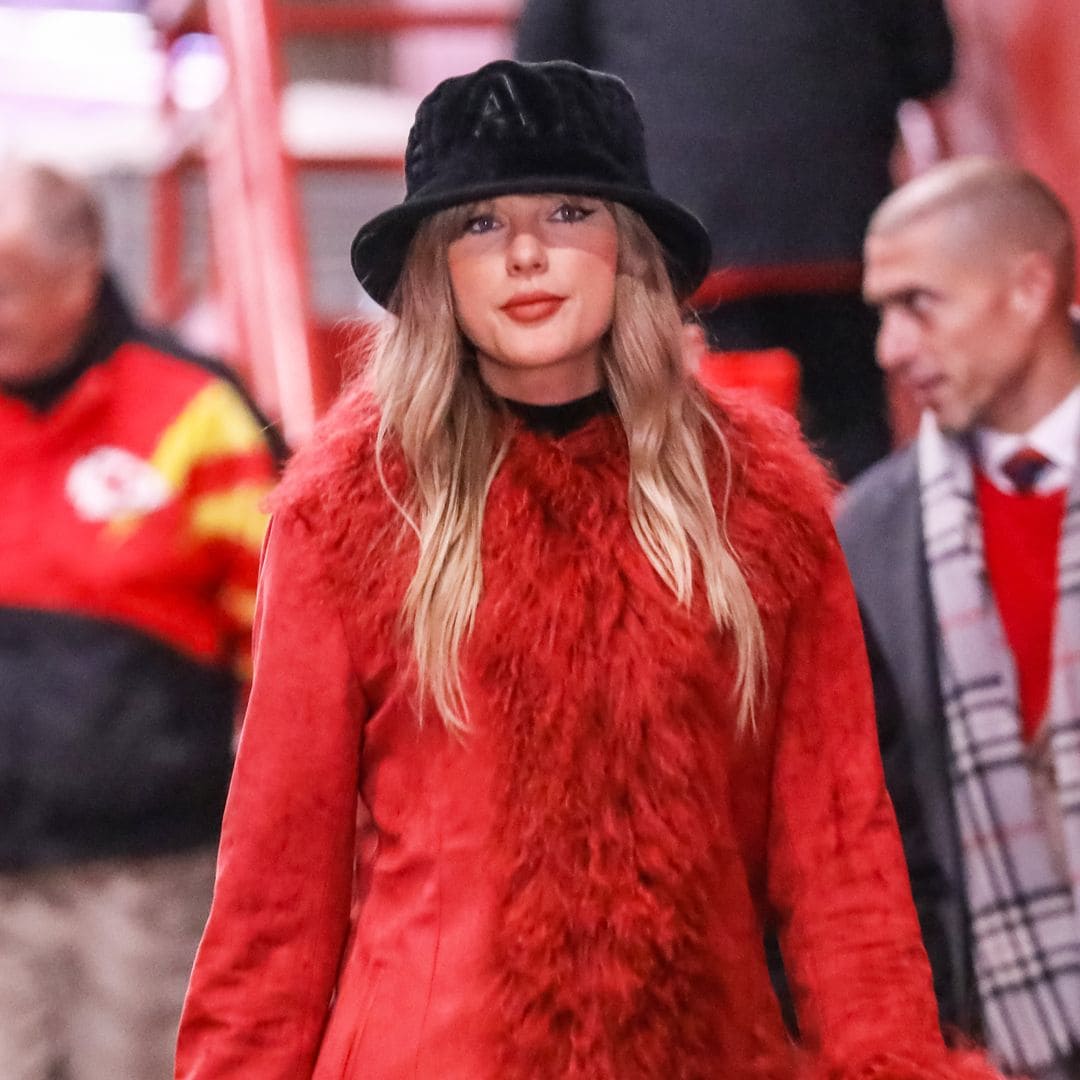 Taylor Swift sorprende en el partido de fútbol de su novio con maxiabrigo rojo y botas de tacón españolas