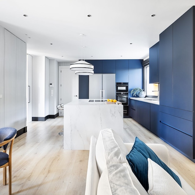 Cocina con muebles azules y blancos abierta al salón