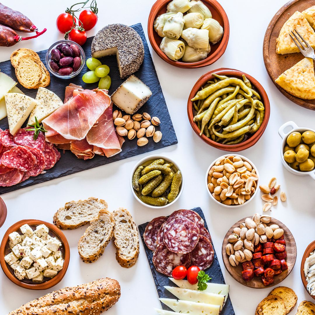 Mesa de aperitivo con tortilla de patatas, anchoas, frutos secos, pan, embutidos...