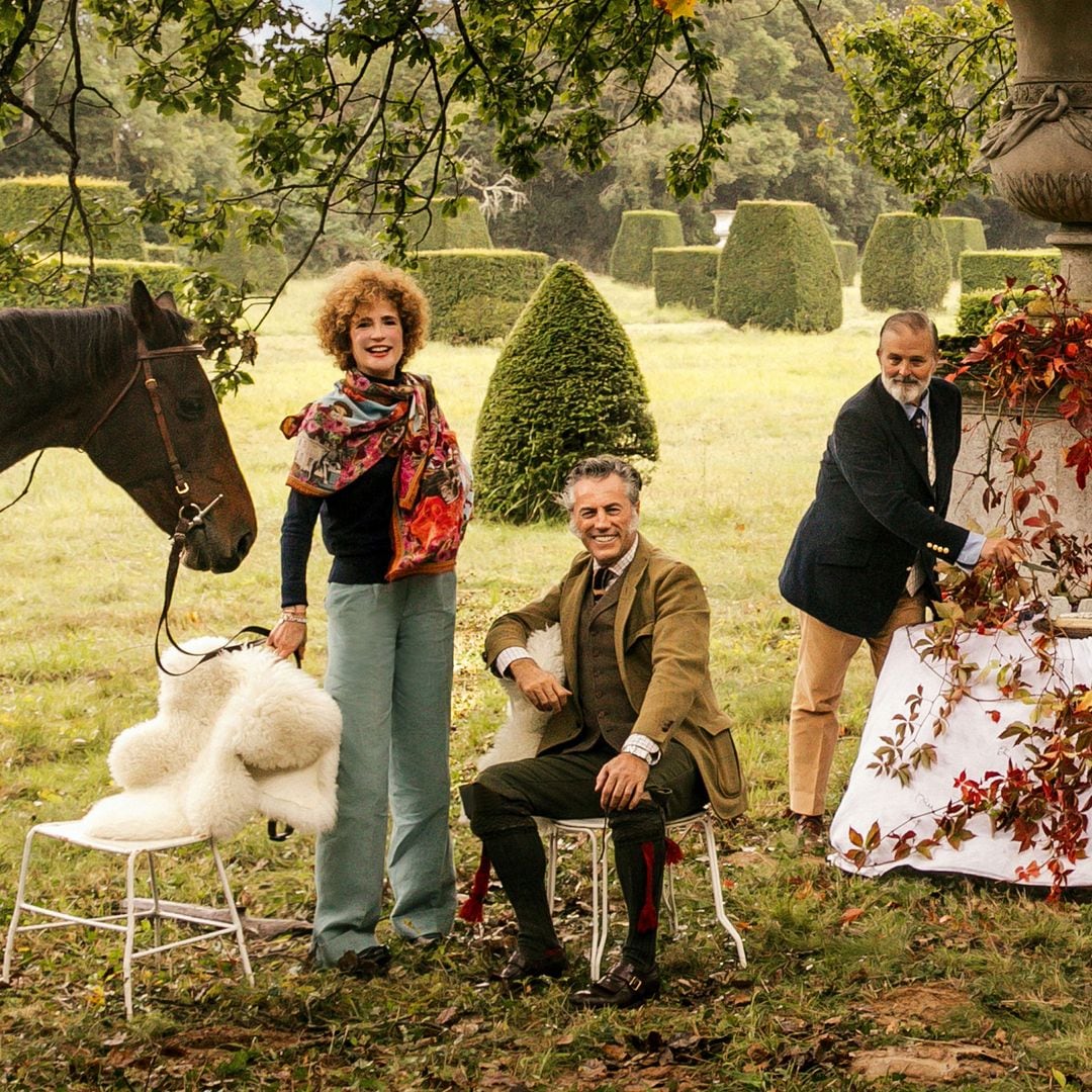 Flore de Brantes posando con sus grandes amigos el artista Ignacio Goitia y Alejandro Muguerza, en el idílico jardín del castillo. Los platos y los cojines están diseñador por Goitia, autor también del fular que lleva la condesa, emulando el dibujo del techo del comedor principal. El coche inglés Break, hecho por Hermès, fue usado originalmente para cazar.