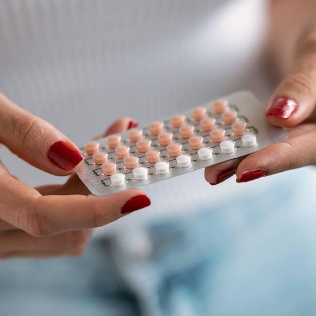 mujer con blister de pastillas anticonceptivas en las manos