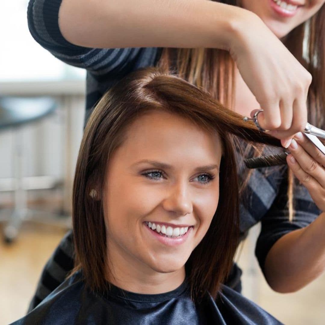 peluquera cortando el cabello a mujer joven