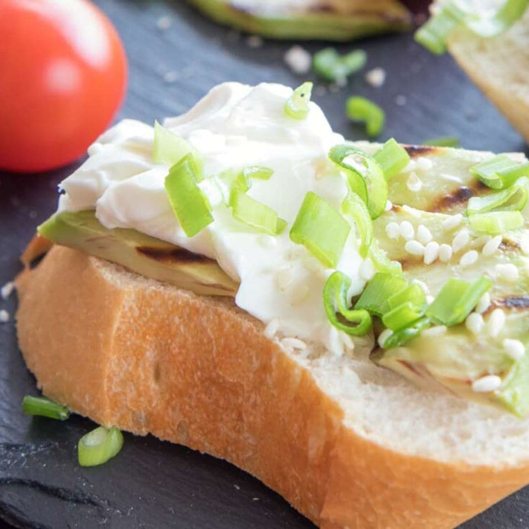 Tostas de aguacate a la parrilla con queso crema, cebolleta y sésamo