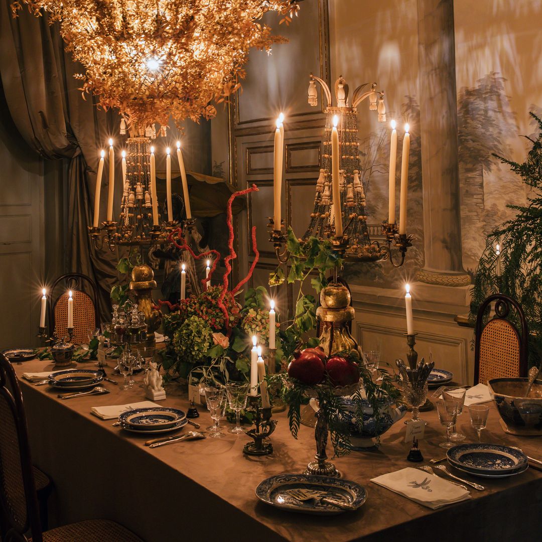 El comedor con decoración de «trompe l’oeil» en las paredes con una lámpara de araña vegetal, hecha con trazos secos de plantas naturales