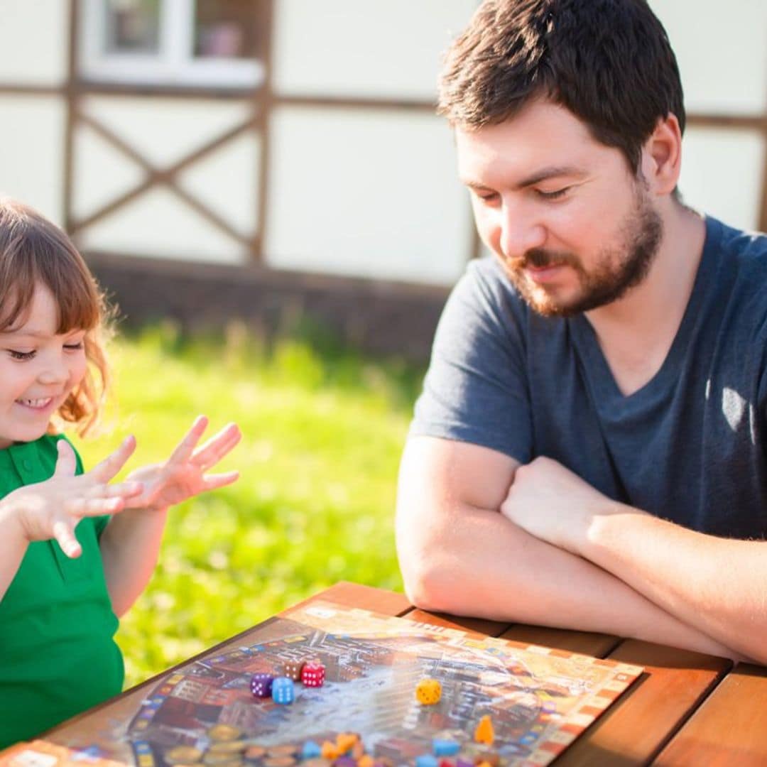 padre jugando con su hija a juego de mesa en el jard n 