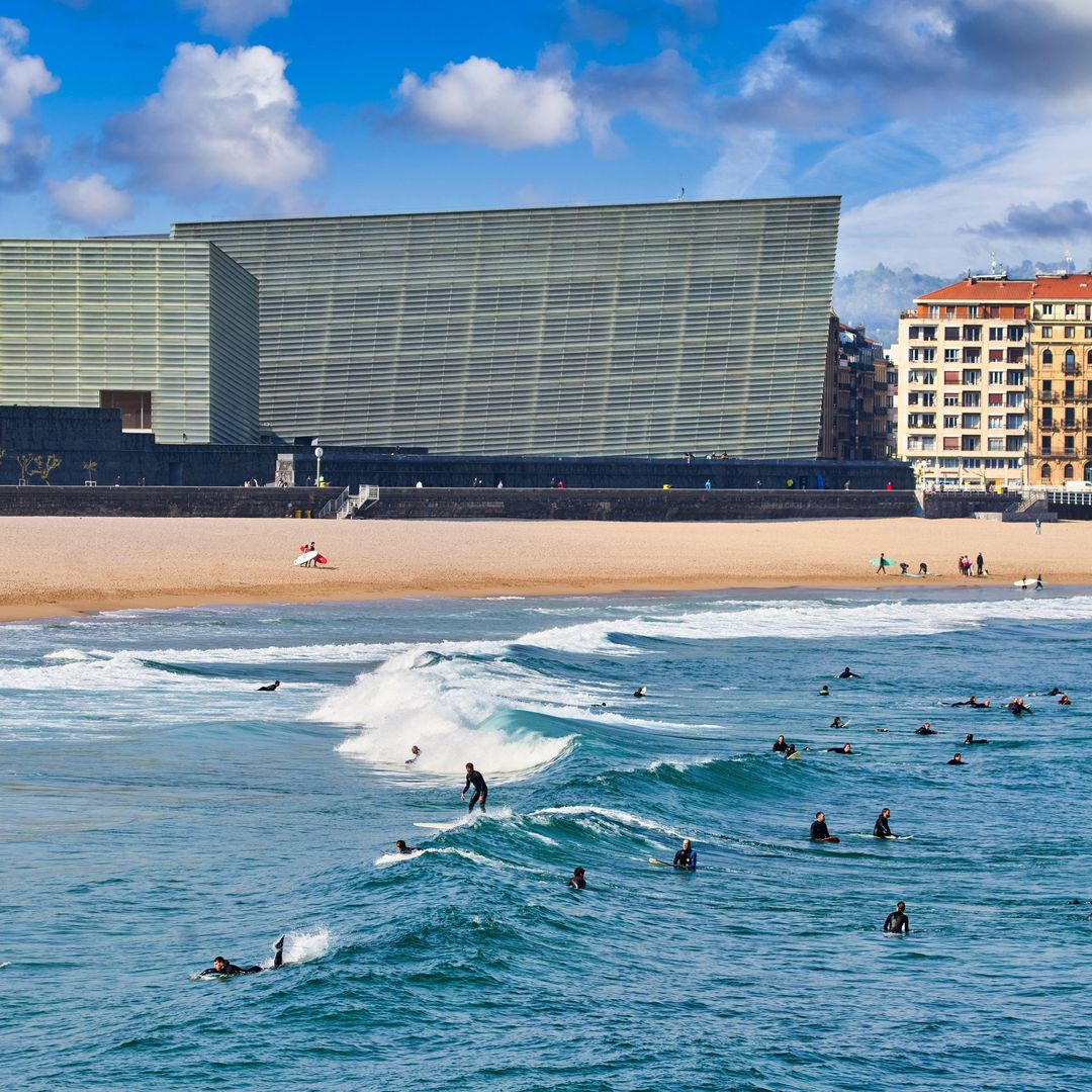 Surfistas en la plaza de Zurriola y el palacio del Kursaal en San Sebastián