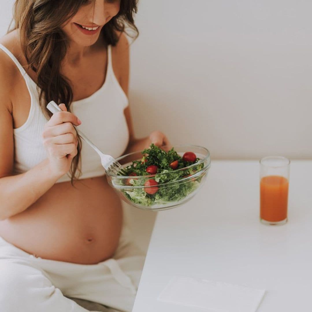 mujer embarazada comiendo saludable en la cocina 