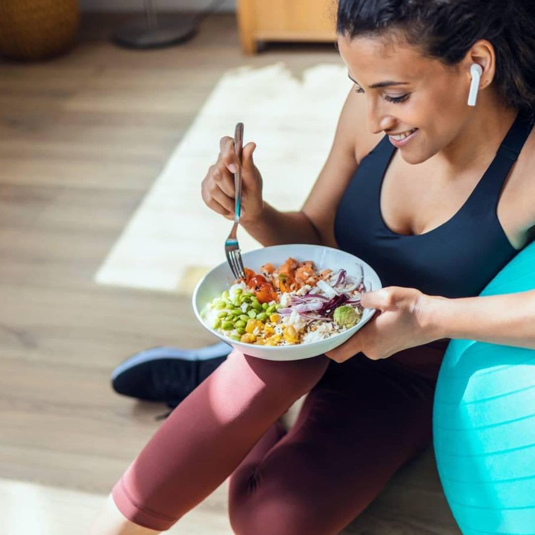 mujer termina de hacer deporte y come comida saludable