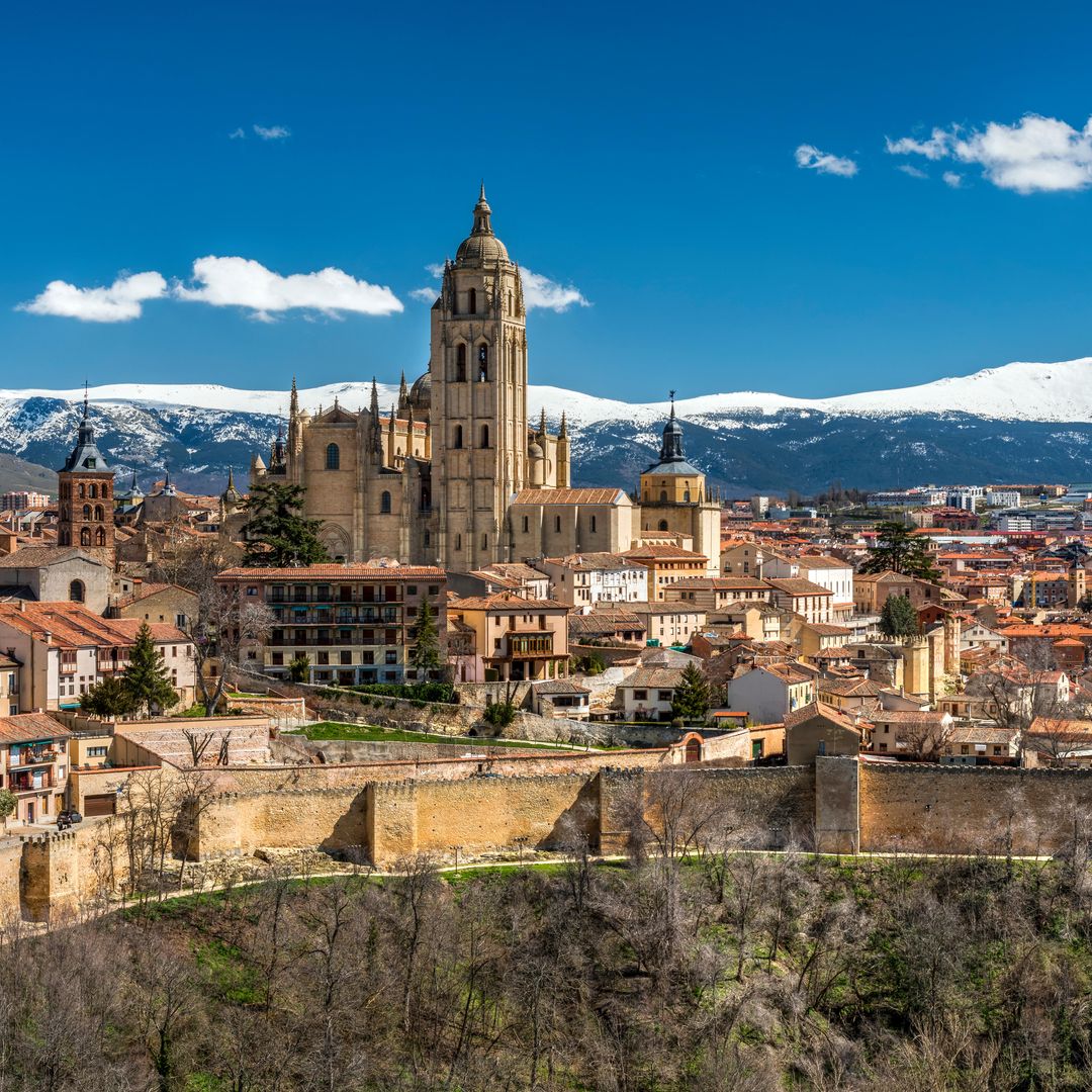 Panorámica de Segovia con la catedral gótica y las montañas nevadas de la sierra de Guadarrama al fondo